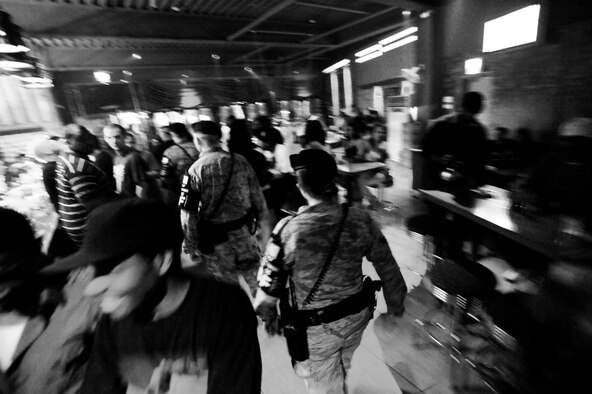 Two security forces Airmen conduct a walkthrough of a bar during their nightly patrol of Songtan Entertainment District outside Osan Air Base, Republic of Korea. Town Patrol is a volunteer position for the Security Forces Airmen here. Teams work together in different areas every night. Their job consists of force protection, blocking traffic within the walking areas and patrols of the many bars, restaurants and off limit areas. While traveling through the streets to each of the facilities, they stay aware of everyone and everything with the primary goal of ensuring safety. ( U.S. Air Force photo/ Senior Airman Stephenie Wade)

