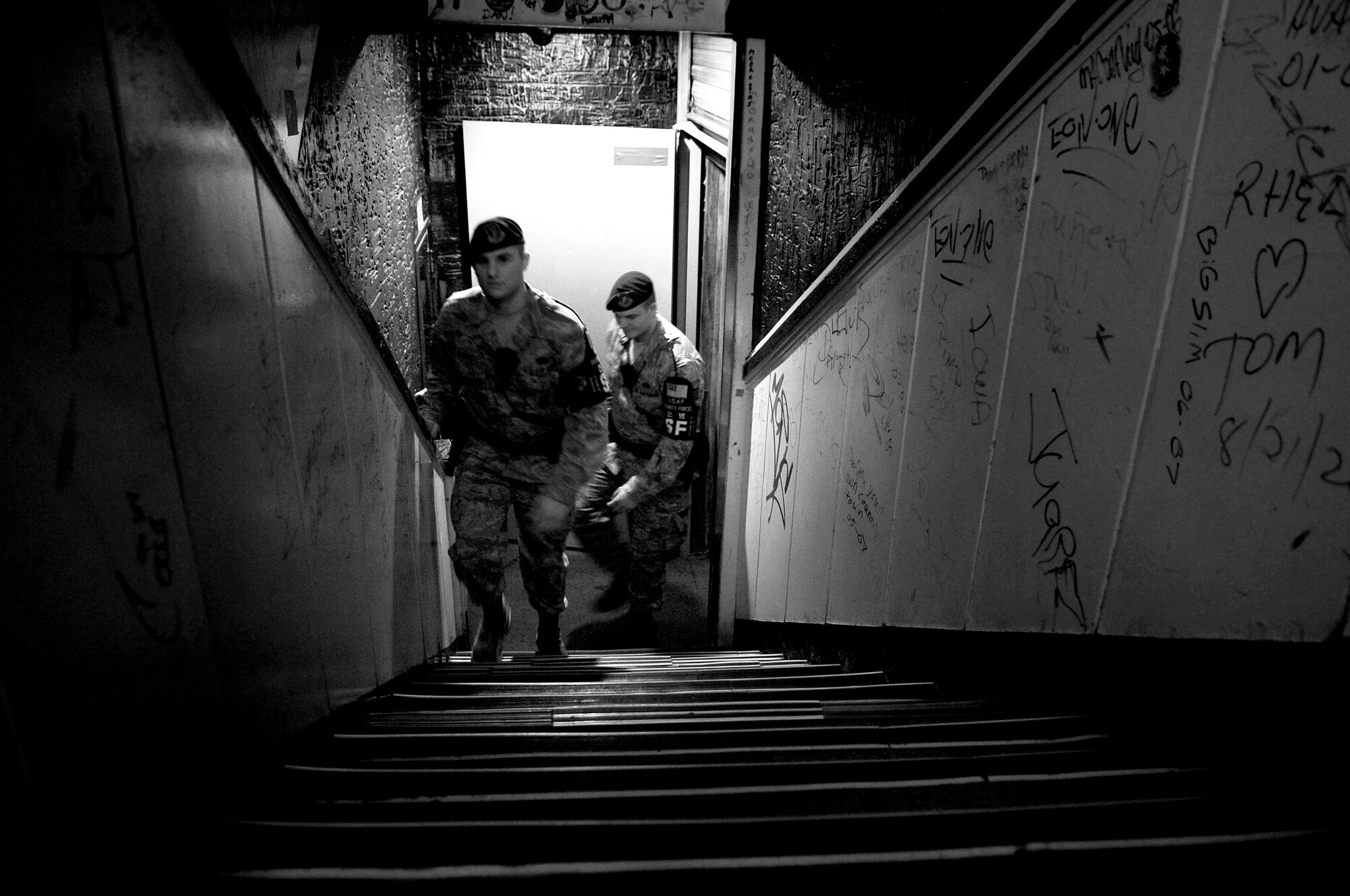 Staff Sergeant Vincent Tentis and Senior Airman Jared Sweeney, 51st Security Forces Squadron Town Patrolmen, exit a bar while conducting their nightly patrol of Songtan Entertainment District outside Osan Air Base, Republic of Korea. Town Patrol is a volunteer position for the Security Forces Airmen here. Teams work together in different areas every night. Their job consists of force protection, blocking traffic within the walking areas and patrols of the many bars, restaurants and off limit areas. While traveling through the streets to each of the facilities, they stay aware of everyone and everything with the primary goal of ensuring safety. ( U.S. Air Force photo/ Senior Airman Stephenie Wade)
