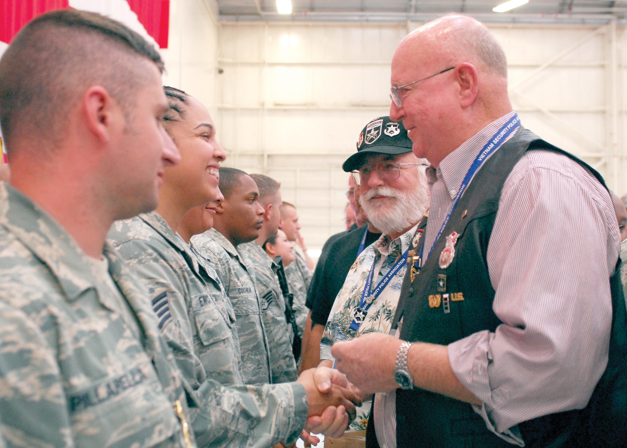 Key leadership with the Vietnam Security Police Association awards coins to members of the 56th Security Forces Squadron during VSPA's visit to Luke Air Force Base as part of the group's 15th annual reunion. The group had the chance to come and tour Luke and attend a variety of demonstrations put on by the 56th SFS as well as a reception held in Hangar 999 Oct. 9. (U.S. Air Force photo by Senior Airman Tracie Forte)