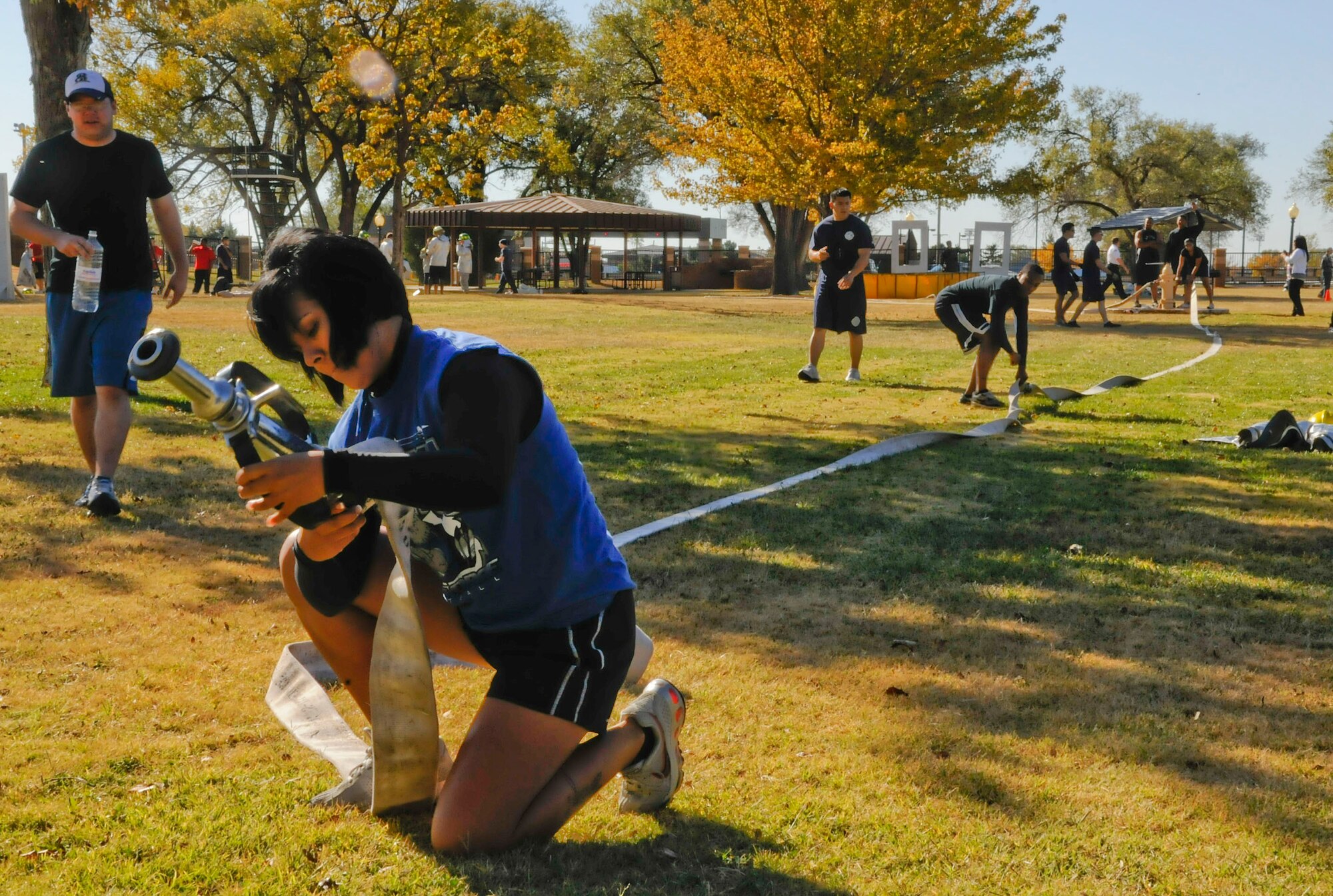 CANNON AIR FORCE BASE, N.M. -- Tech. Sgt. Heather Jones, 27th Special Operations Comptroller Squadron, tightens the nozzle on the hose for a timed event at the annual Fire Prevention Week Oct. 16. In this event, the team members must unravel the hose, hook it up to the hydrant and blow down a hinged door to stop the time. (U.S. Air Force photo/ Senior Airman Erik Cardenas)