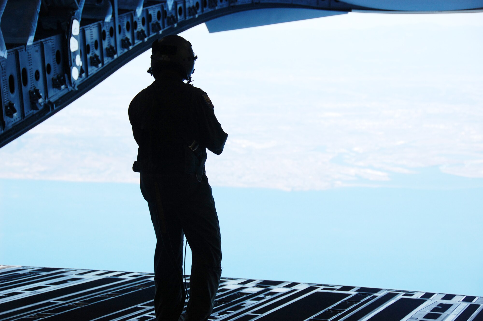 Tech. Sgt. Sidney De Leon checks the proper function of the opening of the C-17 Globemaster III cargo/door ramp in-flight while flying Oct. 15, 2009, along the coast of Long Beach, Calif. Whenever Boeing rolls a new C-17 off the plant, Sergeant De Leon and his team have to make sure it's ready for the Air Force to fly. Sergeant De Leon is a Defense Contract Management Agency C-17 acceptance crew member. (U.S. Air Force photo/Col. Michael Coolidge) 