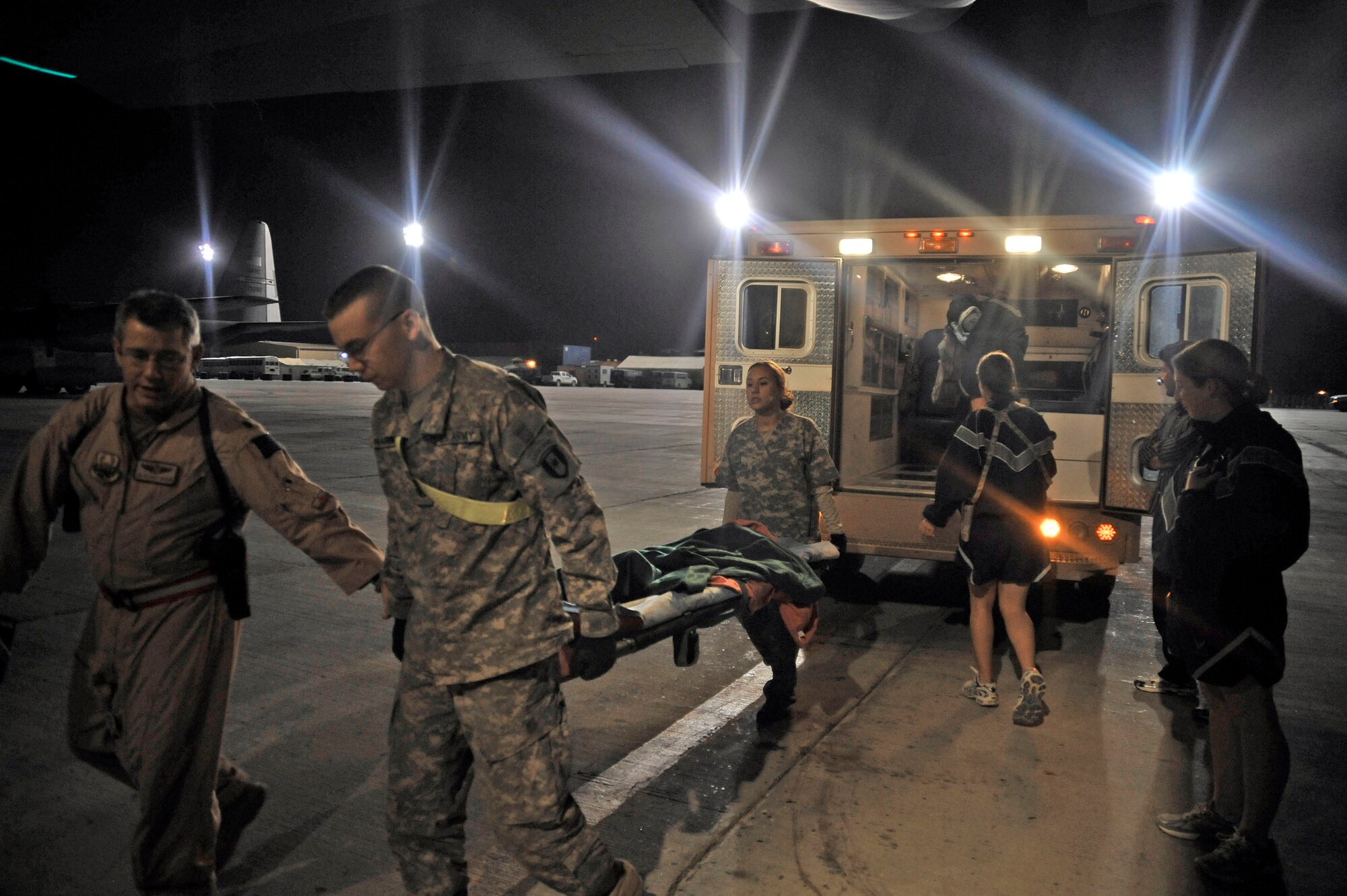 Airmen prepare to transport patients from an HC-130 Hercules during a routine channel mission at Camp Bastion, Afghanistan Oct. 6, 2009. These Airmen are assigned to the 451st Aeromedical Squadron at Kandahar Airfield, Afghanistan. (U.S. Air Force photo/Staff Sgt. Angelita Lawrence)