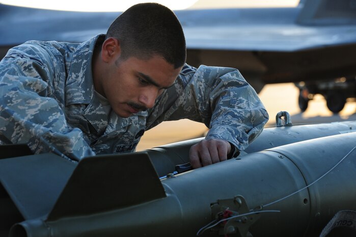 NELLIS AIR FORCE BASE, Nev. -- Airman 1st Class Rodrigo Martinez, 16th Weapons Squadron load crew member, secures a bomb onto a jammer during the Weapons Load Crew Competition on the Nellis  flight line, Oct. 9.  The quarterly weapons load crew competition tests the skills of Airmen on six different teams. The Airmen are judged on speed, accuracy and safety.
(U.S. Air Force Photo / Staff Sgt. William P.Coleman)