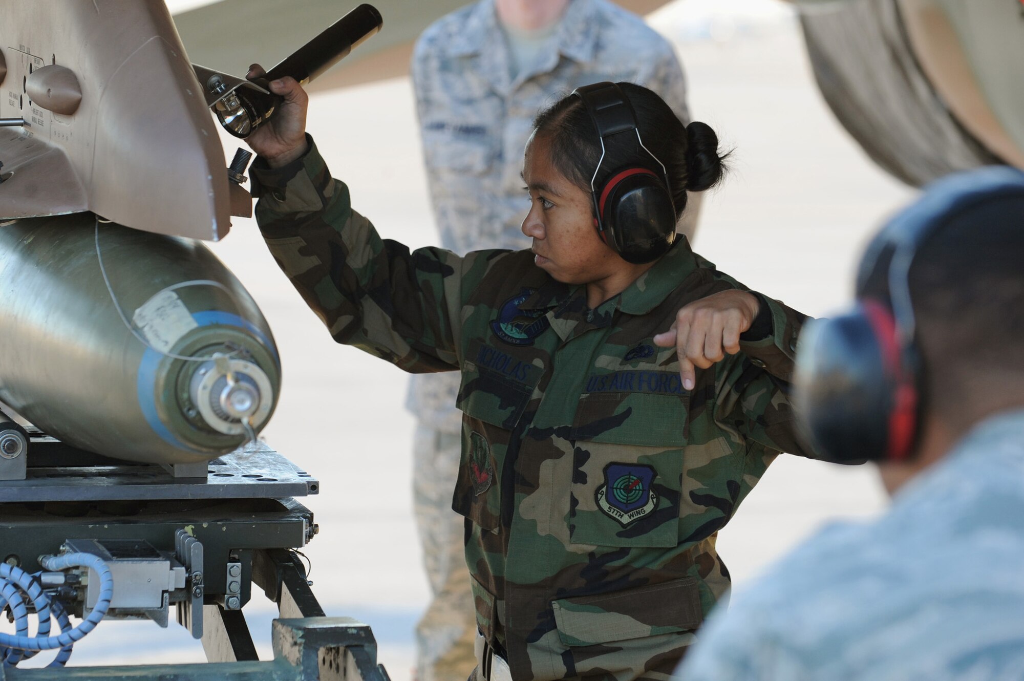 NELLIS AIR FORCE BASE, Nev.-- Staff Sgt. Cherry Nicholas from the  57th Aircraft Maintenance Squadron gives direction to an airman during the Weapons Load Crew Competition on the Nellis flight line, Oct. 9, 2009. The bi-monthly weapons load crew competition tests the skills of Airmen on six different teams. The Airmen are judged on speed, accuracy and safety.
(U.S. Air Force Photo / Airman 1st Class Jamie Nicley)
