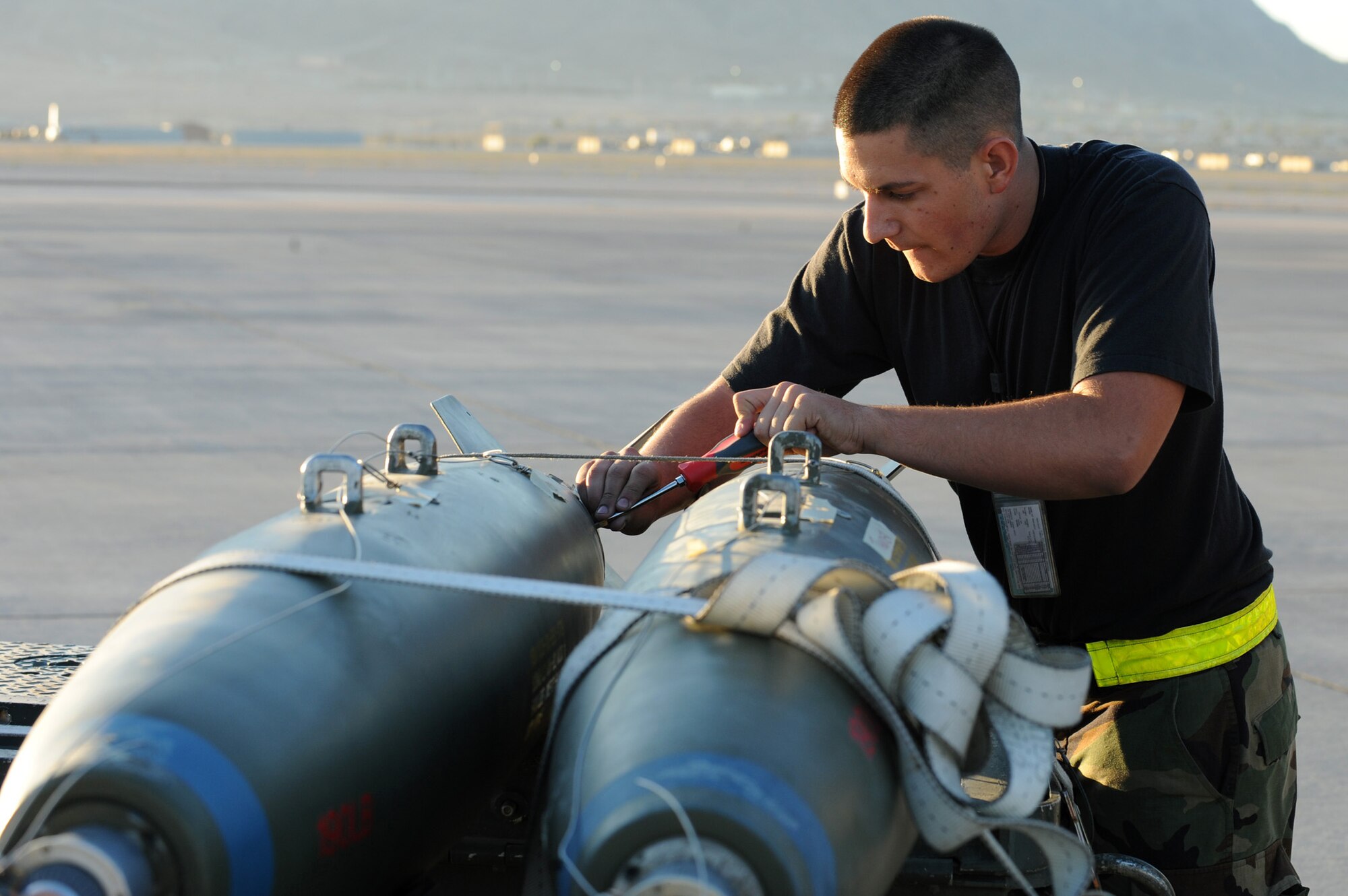 NELLIS AIR FORCE BASE, Nev. -- Airman 1st Class Christopher Mateo, 57th Aircraft Maintenance Squadron tightens screws on an A-10 Thunderbolt II dummy bomb during the Weapons Load Crew Competition on the Nellis flight line, Oct. 9, 2009. The bi-monthly weapons load crew competition tests the skills of Airmen on six different teams. The Airmen are judged on speed, accuracy and safety.
(U.S. Air Force Photo / Airman 1st Class Jamie Nicley)
