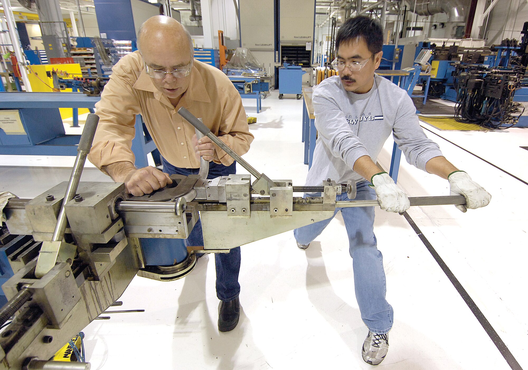 A lot of knowledge, skill, preparedness and a little muscle equaled a recipe that kept an E-3 Sentry in the fight when Tinker provided a tube critical for the rotodome radar’s coolant system.  Work leader Robert Pierson, left, and metal tube maker Willy Poblete bend a similar 60-inch tube in the 76th Commodities Maintenance Group’s Tubing and Cable Shop, Bldg. 3705.  (Air Force photo by Margo Wright)