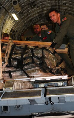Capt. Nate Padgett, a pilot from the 535th Airlift Squadron at Hickam Air Force, Hawaii, assists aircrew members in unloading cargo from a C-17 Globemaster III Oct 19. Captain Padget and 149 other Airmen are participating in Cope India, a United States and India humanitarian assistance and disaster relief mission Oct. 15-24. (U.S. Air Force photo/ Capt. Genieve David)