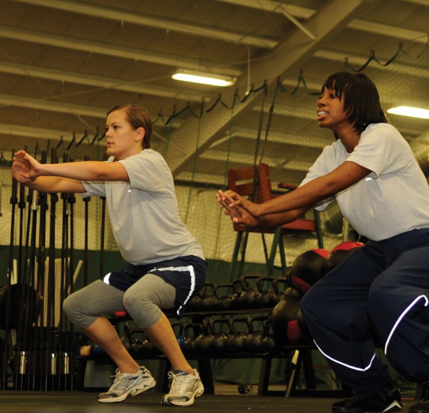 Airman 1st Class Megan Dykstra, 316th Force Support Squadron customer service representative, and Airman 1st Class Jenerian Walters, 316 FSS career development technician, gives their all in a CrossFit competition in the Tactical Fitness Center recently. Completing 10 repetitions, Airman Dykstra finished 2nd in the women's bracket of the completion. (U.S. Air Force photo/ Staff Sgt. Keyonna Fennell)