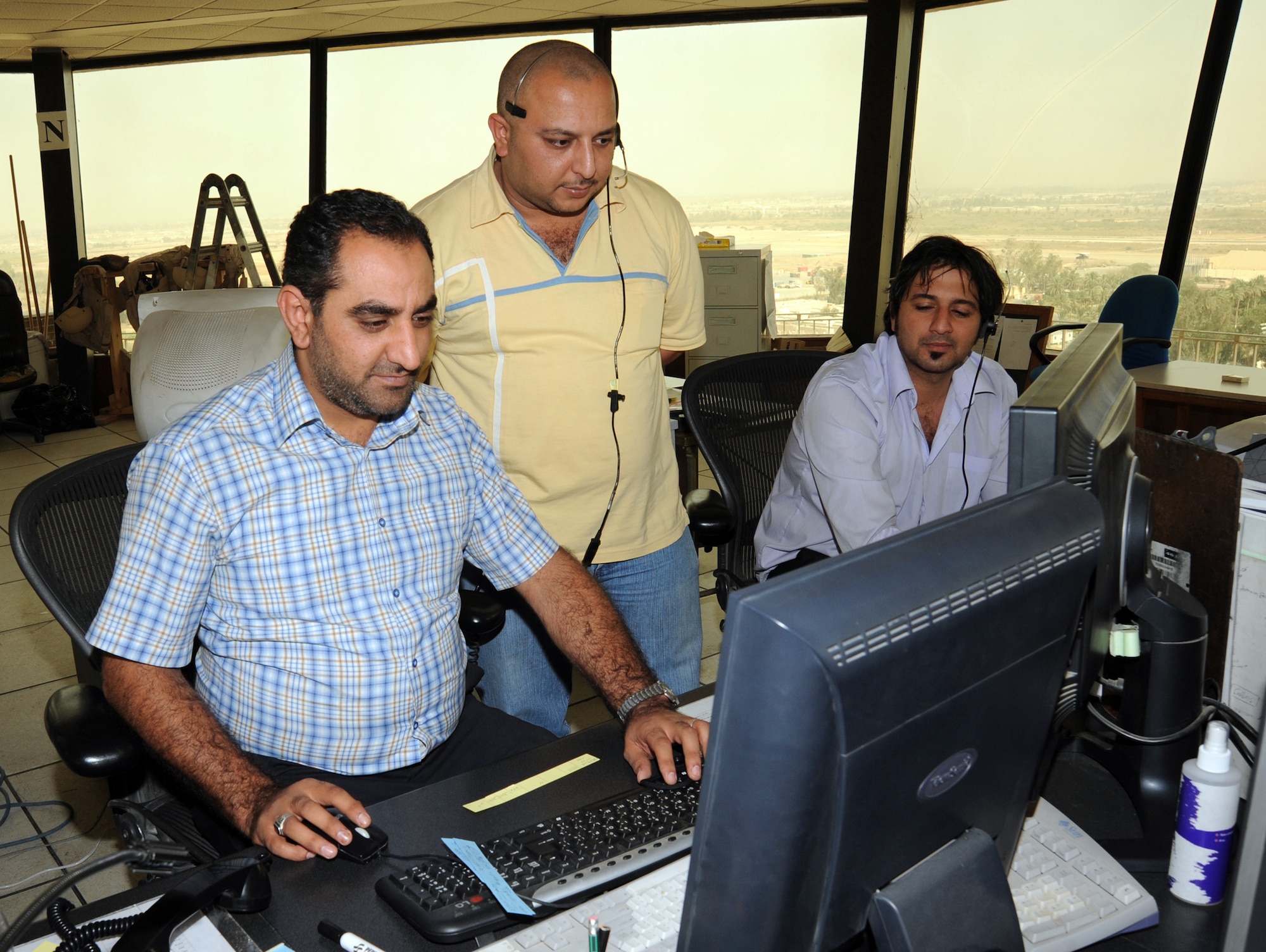 Ali Thamer (center), a Baghdad International Airport tower manager, observes fully qualified and licensed Iraqi air traffic controllers manage traffic in the Baghdad airspace Oct. 14, 2009. Air traffic control operations were conducted by Iraqis and U.S. Airmen assigned to the 447th Expeditionary Operations Support Squadron at Sather Air Base, while more Iraqis were training to become certified. Airmen were able to fully turn over air traffic control duties to the Iraqis as of Oct.1. The 447th EOSS Airmen now focus on military flights arriving and departing from BIAP.  (U.S. Air Force photo/Tech. Sgt. Johnny L. Saldivar)