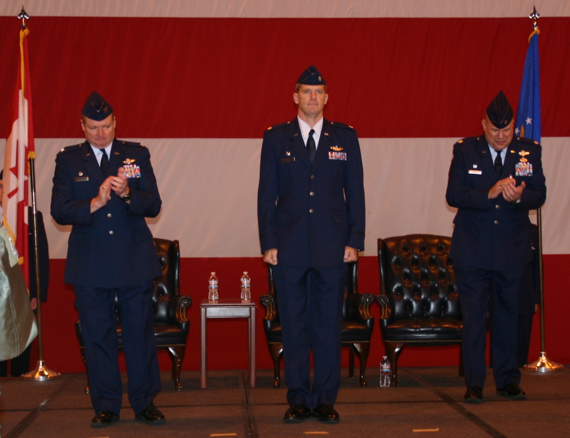 Col. George Carpenter (left), commander, 552nd Operations Group, applauds Lt. Col. David Evans (center) after he accepted command of the 552nd Training Squadron from Lt. Col. John Iwanski (right). US Air Force Photo / 1Lt Kinder Blacke