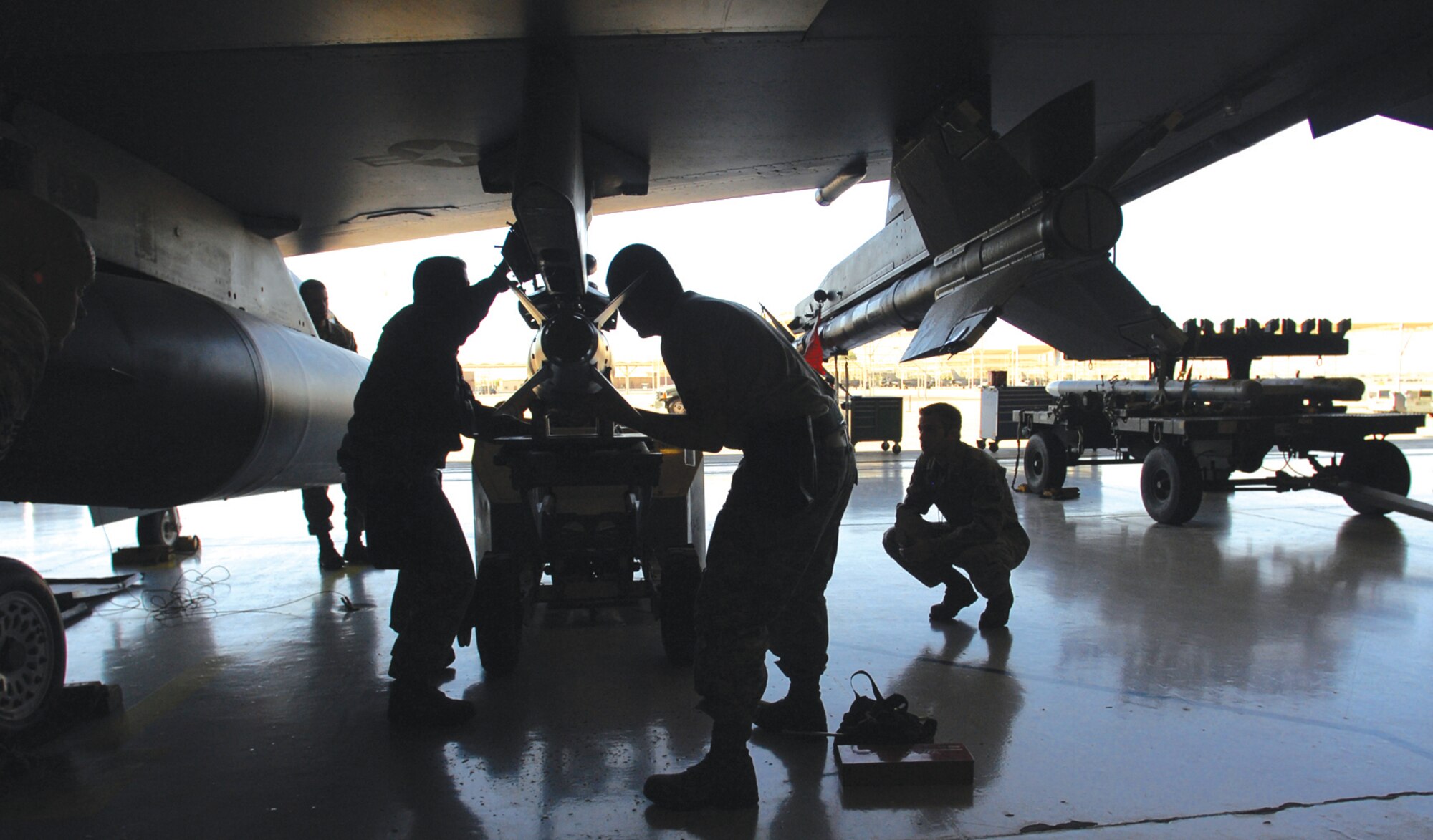A team from the 310th Aircraft Maintenance Unit attaches an MK-82K HD bomb during the quarterly weapons lead crew competition, Oct. 9 at Luke Air Force Base, Ariz. The competition pitted load crews from five of Luke's AMUs against each other in a loading competition evaluated by weapons standardizations personnel. (U.S. Air Force photo by Airman 1st Class Sandra Welch)