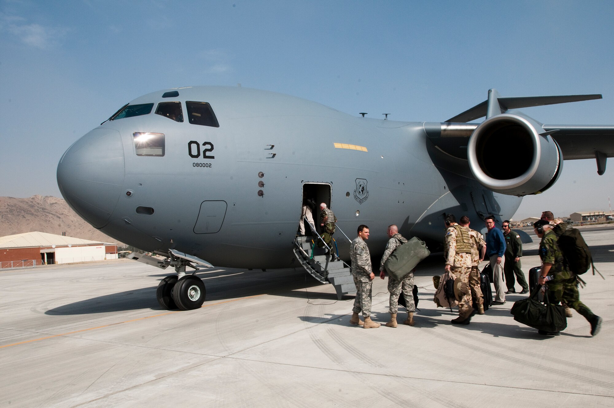 KABUL, Afghanistan - Members of the NATO International Military Committee board a C-17 from the multinational Heavy Airlift Wing, Papa Air Base, Hungary. The newly formed HAW, flew one of its three C-17 Globemaster IIIs into Kabul with military representatives from all 28 NATO member states as well as those from the 14 non-NATO nations who also contribute forces to ISAF. The consortium includes NATO member nations Bulgaria, Estonia, Hungary, Lithuania, the Netherlands, Norway, Poland, Romania, Slovenia and the U.S., as well as Partnership for Peace nations Finland and Sweden. (Photo by Petty Officer 1st Class Ryan Tab)