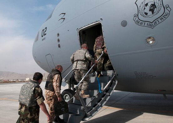KABUL, Afghanistan - Members of the NATO International Military Committee board a C-17 from the multinational Heavy Airlift Wing, Papa Air Base, Hungary. The newly formed HAW, flew one of its three C-17 Globemaster IIIs into Kabul with military representatives from all 28 NATO member states as well as those from the 14 non-NATO nations who also contribute forces to ISAF. The consortium includes NATO member nations Bulgaria, Estonia, Hungary, Lithuania, the Netherlands, Norway, Poland, Romania, Slovenia and the U.S., as well as Partnership for Peace nations Finland and Sweden. (Photo by Petty Officer 1st Class Ryan Tab)