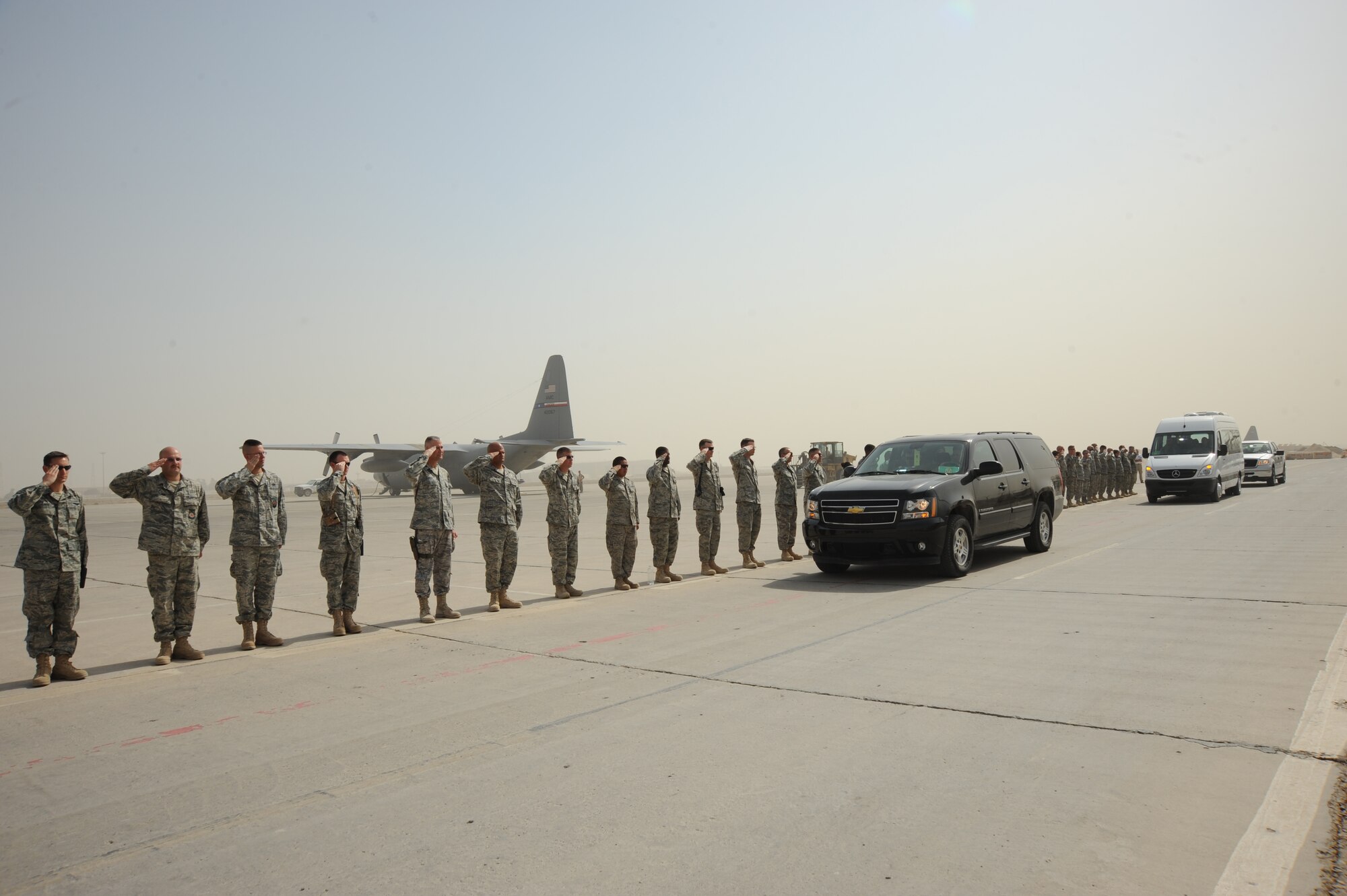 SATHER AIR BASE, Iraq -- Airmen from the 447th Air Expeditionary Group render a salute for the eight servicemembers, who were taking part in Operation Proper Exit, here Oct.11.  The program allows servicemembers who sustained injuries in combat to return to the camps or bases which they were stationed at when injured.   (U.S. Air Force photo / Staff Sgt. Misty D. Slater)