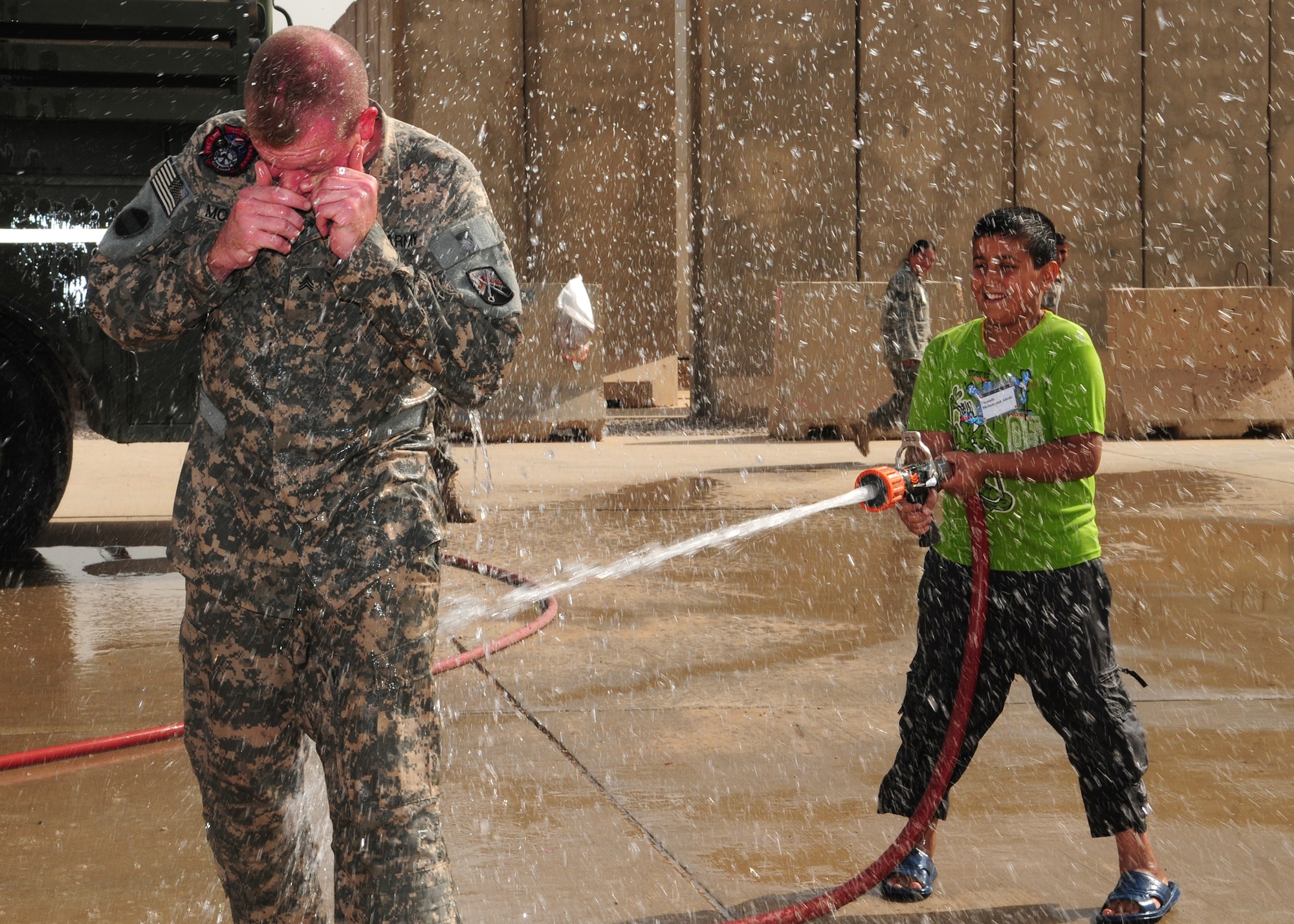 JOINT BASE BALAD, Iraq -- An Iraqi boy soaks Army Sgt. Joshua McGinnis, 23rd
Ordnance Company firefighter, during the Iraqi Kids Day here Oct. 10, 2009.
Sergeant McGinnis is deployed here from Grafenwoehr, Germany, and is a
native of Springfield, Mo. (U.S. Air Force photo/Staff Sgt. Heather M.
Norris) 