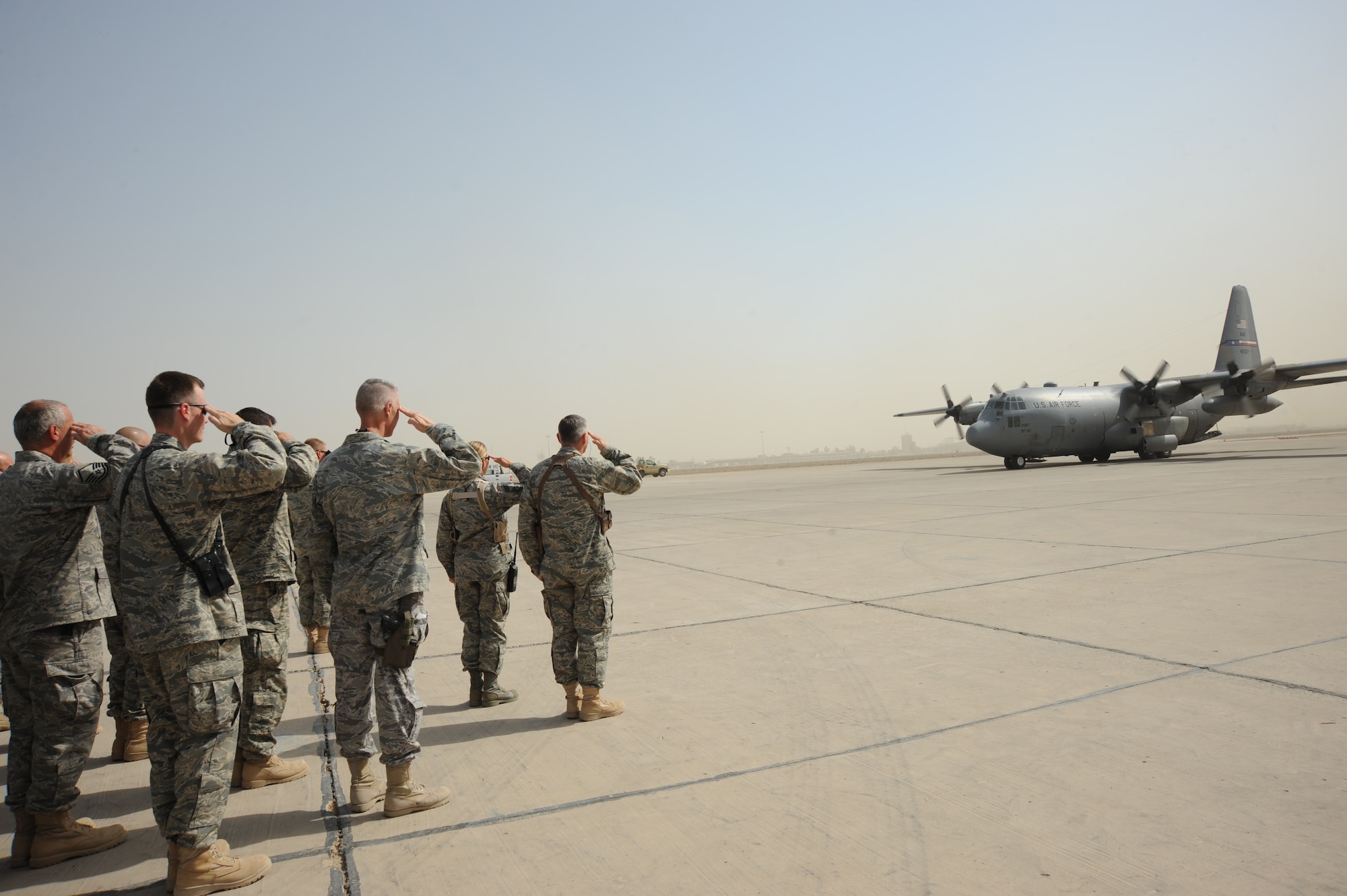 SATHER AIR BASE, Iraq -- Airmen from the 447th Air Expeditionary Group render a salute for the eight servicemembers aboard the C-130, who were taking part in Operation Proper Exit, Oct. 11.  The program allows servicemembers who sustained injuries in combat to return to the camps or bases which they were stationed at when injured.   (U.S. Air Force photo / Staff Sgt. Misty D. Slater)