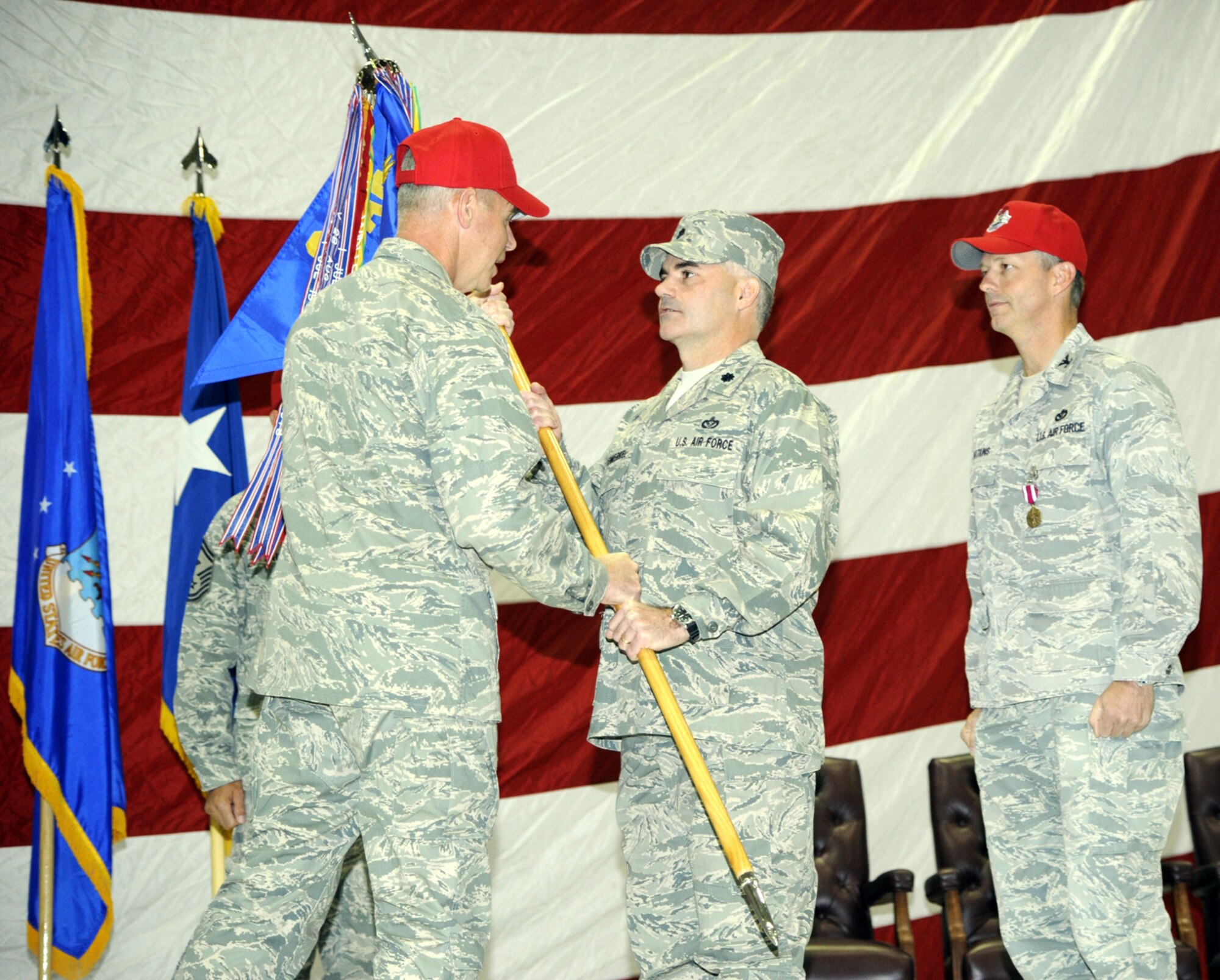 Lt. Col. Gregory Rosenmerkel accepts command of the 819 RED HORSE Squadron from Maj. Gen. William Holland, 9th Air Force commander, Oct. 14 at the 3 Bay Hangar. Col. Terry Watkins, outgoing 819th RHS commander, looks on. (U.S. Air Force photo/Beau Wade)
