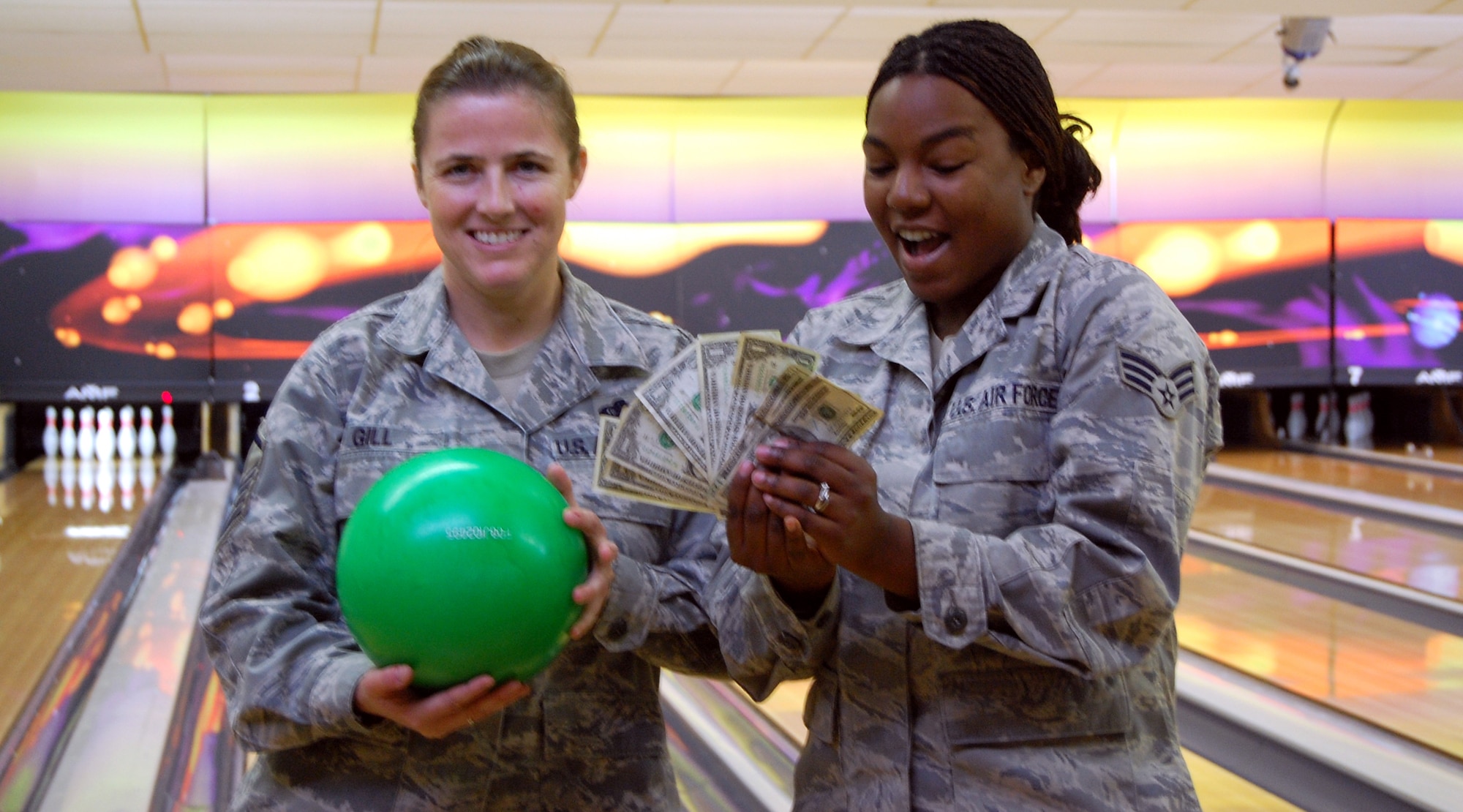 Master Sgt. Stephanie Gill, 341st Communications Squadron, and Senior Airman Jessica Morris, 341st Maintenance Operations Squadron, are excited about the prospect of winning some extra holiday cash competing in the 9-pin no-tap bowling tournament Nov. 20 from 5 to 8 p.m. The event is one of six Operation Holiday Cheer events open to all active-duty members at Malmstrom and offers cash prizes -- $300, $200 and $100 respectively -- to the top three finishers. Anyone who competes in an event is eligible to win the grand prize, two round-trip airline tickets to anywhere in the United States that will be given away at the wrap up party Dec. 17. For complete details, visit www.341fss.com. (U.S. Air Force photo/Valerie Mullett)