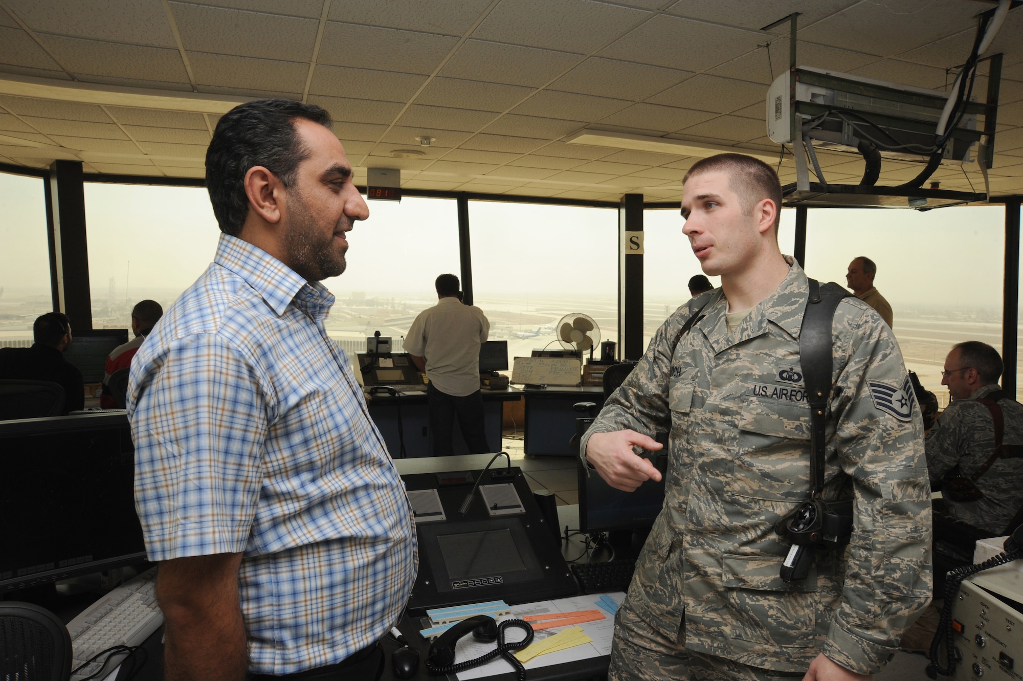BAGHDAD -- Air Force Staff Sgt. Bradley Rich, 447th Expeditionary Operations Support Squadron air traffic control liaison, coordinates the arrival of a military aircraft here with an Iraqi ATC shift supervisor Oct. 14, 2009. Air traffic control operations were conducted by Iraqis and U.S. Airmen assigned to the 447 EOSS at Sather Air Base, while more Iraqis trained with the Washington Consulting Group, an American contracted company. Airmen were able to fully turn over air traffic control duties to the Iraqis as of Oct.1.  The Airmen now focus on military flights arriving and departing from BIAP. Sergeant Rich is deployed from Tinker Air Force Base, Okla., and hails from Longview, Texas. (U.S. Air Force photo/Tech. Sgt. Johnny L. Saldivar)
