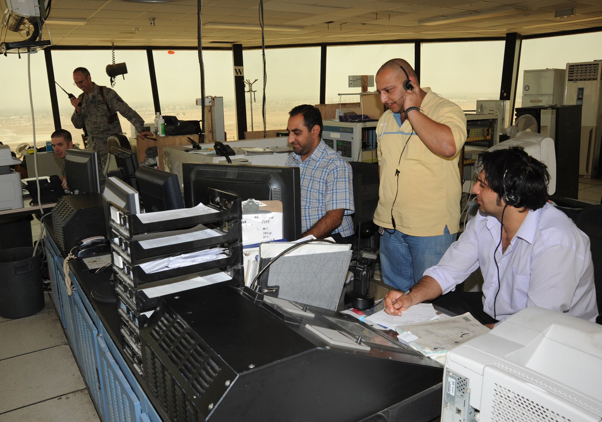 BAHDAD -- Ali Thamer (standing left), Baghdad International Airport tower manager, observes fully qualified and licensed Iraqi air traffic controllers manage traffic in the airspace here Oct. 14, 2009. Air traffic control operations were conducted by Iraqis and U.S. Airmen assigned to the 447th Expeditionary Operations Support Squadron at Sather Air Base, while more Iraqis trained with the Washington Consulting Group, an American contracted company. Airmen were able to fully turn over air traffic control duties to the Iraqis as of Oct.1.  The 447th EOSS Airmen now focus on military flights arriving and departing from BIAP. (U.S. Air Force photo/Tech. Sgt. Johnny L. Saldivar)