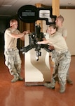 Airman 1st Class Michael Valeich (left), Airman David Mudd and Airman Basic Cortney Wilkinson, all with the 342nd Training Squadron, push a Lawrence Radial Engine while helping to pack up exhibits Oct. 7 at the History and Traditions Museum. (U.S. Air Force photo/Robbin Cresswell) 