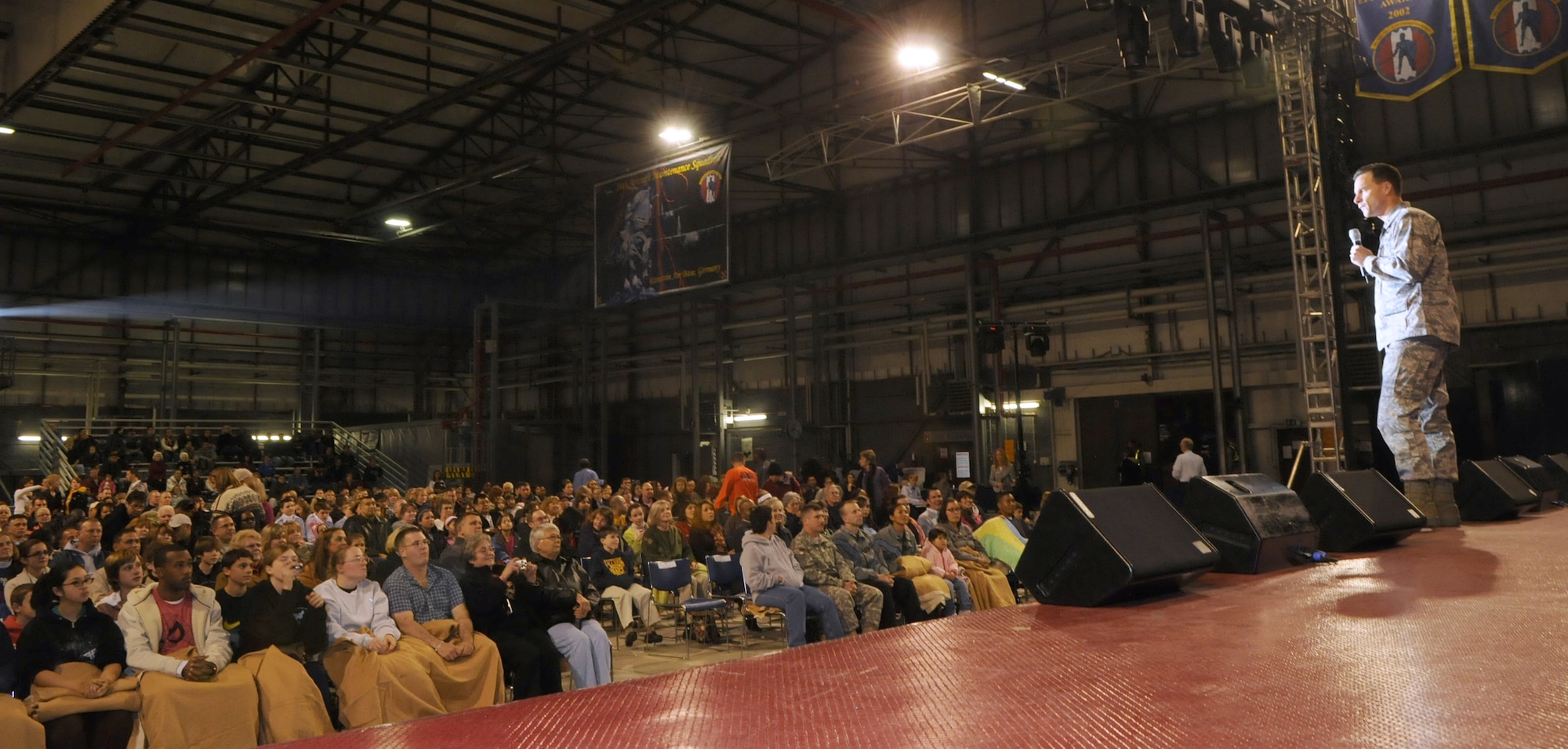 Brig. Gen Mark Dillon, 86th Airlift Wing Commander introduces the 2009 Tops in Blue performance group to a hanger full of military members and their families October 15, 2009, Ramstein Air Base Germany.  Each year Air Force personnel worldwide compete in base talent contests and the most talented move on to higher levels of competition.  The result is an elite group composed of approximately 35 of the most talented competitors.  Their main purpose is to perform for military personnel and their families throughout the world.  (U.S. Air Force Photo by: Tech. Sgt. Sean M. White)