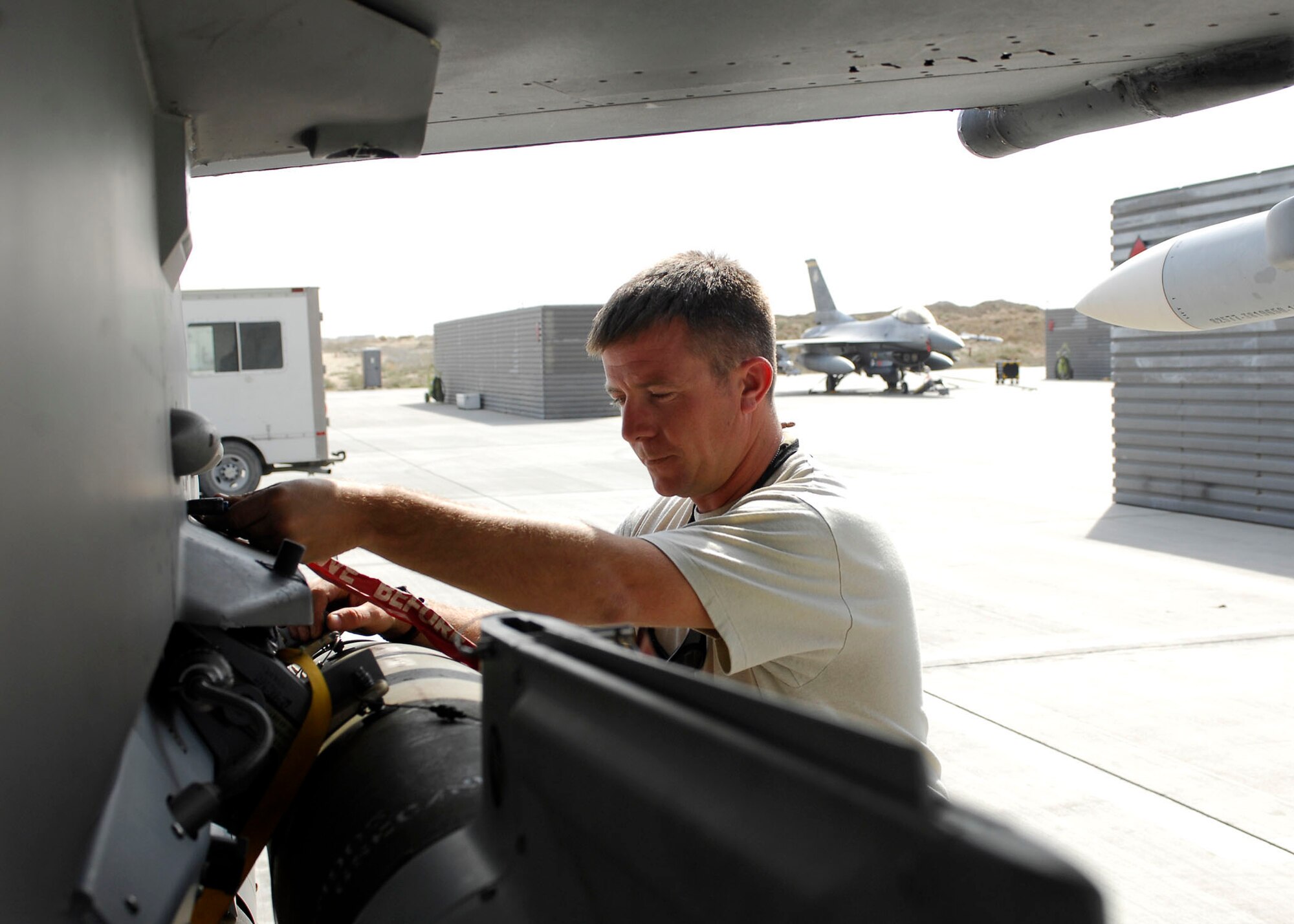 BAGRAM AIRFIELD, Afghanistan -- Technical Sgt. Jim Frey, a weapon expediter from the 79th Aircraft Maintenance Unit, assures bombs are loaded properly on an F-16 Fighting Falcon here, Oct. 16, 2009.  Weapon expediters inspect the aircraft and bombs to ensure the aircraft is safe for the pilot.  Sergeant Frey is deployed from Shaw Air Force Base, S.C., and hails from Lock Haven, Pa.  (U.S. Air Force photo/Senior Airman Felicia Juenke)