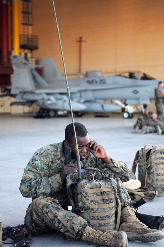 Sgt. Detren Tate, radio operator with Company A, 1st Battalion, 2nd Marine Regiment, programs his radio equipment on the flight line at the Marine Corps Air Station in Yuma, Ariz., prior to a long-distance night helicopter raid exercise Oct. 16, 2009. The company took off from Yuma in six CH-53s and two MV-22 Ospreys to seize an airfield and rescue an enemy defector and his family, as well as retrieve valuable communication equipment, at Fort Huachuca near Tucson, Ariz. The training was in preparation for the battalion’s upcoming deployment to Afghanistan in the spring of 2010.