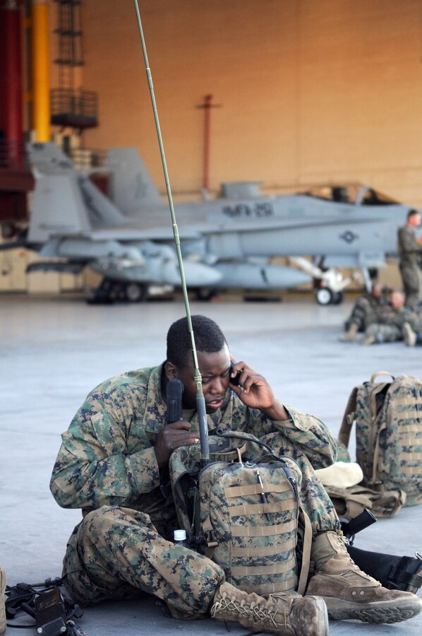 Sgt. Detren Tate, radio operator with Company A, 1st Battalion, 2nd Marine Regiment, programs his radio equipment on the flight line at the Marine Corps Air Station in Yuma, Ariz., prior to a long-distance night helicopter raid exercise Oct. 16, 2009. The company took off from Yuma in six CH-53s and two MV-22 Ospreys to seize an airfield and rescue an enemy defector and his family, as well as retrieve valuable communication equipment, at Fort Huachuca near Tucson, Ariz. The training was in preparation for the battalion’s upcoming deployment to Afghanistan in the spring of 2010.