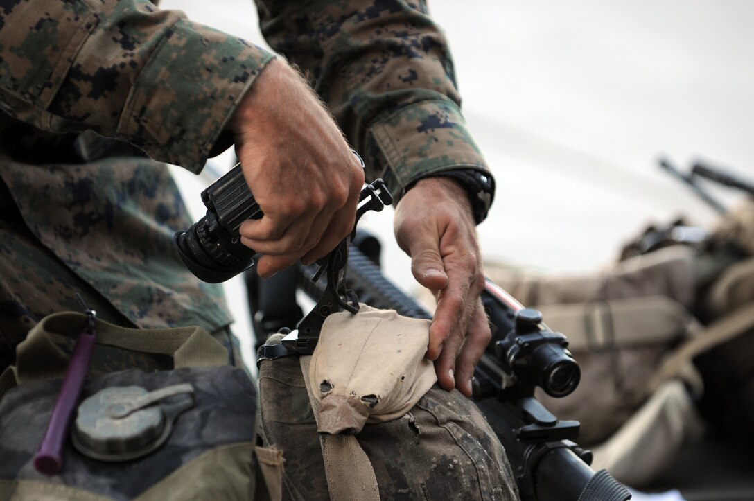 Lance Cpl. Michael Sawicki, assaultman with Company A, 1st Battalion, 2nd Marine Regiment, secures his night vision attachment to his Kevlar helmet on the flight line at the Marine Corps Air Station in Yuma, Ariz., Oct. 16, 2009, in preparation of the company’s long-distance night helicopter raid exercise later that evening. The company took off from Yuma in six CH-53s and two MV-22 Ospreys to seize an airfield and rescue an enemy defector and his family, as well as retrieve valuable communication equipment, at Fort Huachuca near Tucson, Ariz. The training was in preparation for the battalion’s upcoming deployment to Afghanistan in the spring of 2010.