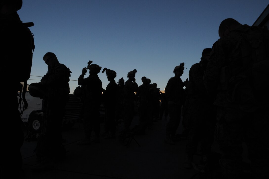 Marines from Company A, 1st Battalion, 2nd Marine Regiment, gear up on the flight line at the Marine Corps Air Station in Yuma, Ariz., just prior to beginning a long-distance night helicopter raid exercise Oct. 16, 2009. The company took off from Yuma in six CH-53s and two MV-22 Ospreys to seize an airfield and rescue an enemy defector and his family, as well as retrieve valuable communication equipment, at Fort Huachuca near Tucson, Ariz. The training was in preparation for the battalion’s upcoming deployment to Afghanistan in the spring of 2010.