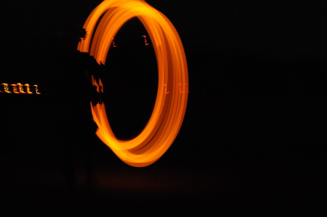 A Marine from Company A, 1st Battalion, 2nd Marine Regiment, spins a glow stick on a string to signal a CH-53 helicopter for pick up on the flight line at Fort Huachuca in Tucson, Ariz., during a long-distance night helicopter raid exercise Oct. 16, 2009. The company took off from Yuma in six CH-53s and two MV-22 Ospreys to seize an airfield and rescue an enemy defector and his family, as well as retrieve valuable communication equipment, at Fort Huachuca near Tucson, Ariz. The training was in preparation for the battalion’s upcoming deployment to Afghanistan in the spring of 2010.
