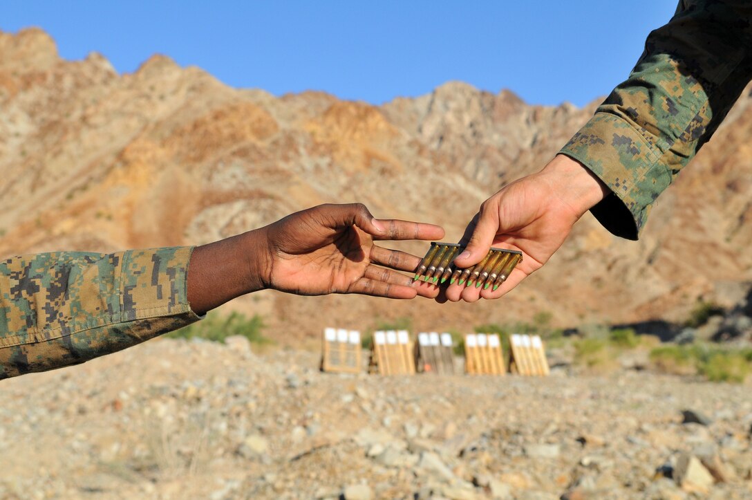 Lance Cpl. Jarvis Rogers, company clerk, hands out rounds to a Company A, 1st Battalion, 2nd Marine Regiment, Marine calibrating his weapon sight at the Camp Billy Machen desert warfare training facility in the Chocolate Mountain Aerial Gunnery Range in California Oct. 17, 2009. The Camp Lejeune, N.C.-based company spent three days at the camp, making use of its rocky, mountainous terrain to prepare for an upcoming deployment to Afghanistan early next year. While at the camp, the Marines carried out fire team live-fire ambush and reaction drills as well as squad-sized combat patrols. Rogers, 20, is an Atlanta native.