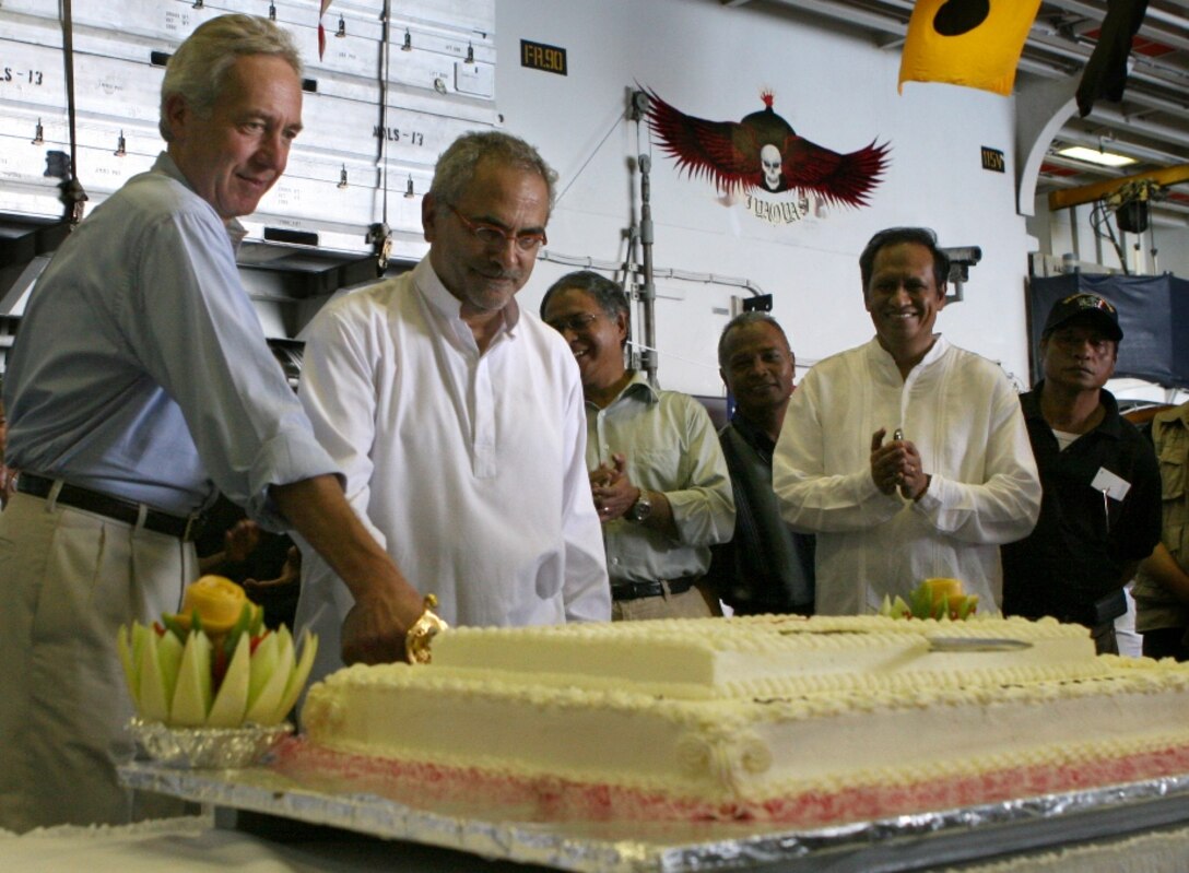 The president of Timor Leste, Jose Manuel Ramos-Horta and US ambassador to Timor Leste, Hans Klemm, cut a cake aboard assault ship Bonhomme Richard Oct. 17 in recognition of the multilateral exercise underway in Timor Leste. This exercise focuses on medical, dental and engineering projects and military interaction between the Timor Leste military and members of the 11th Marine Expeditionary Unit.