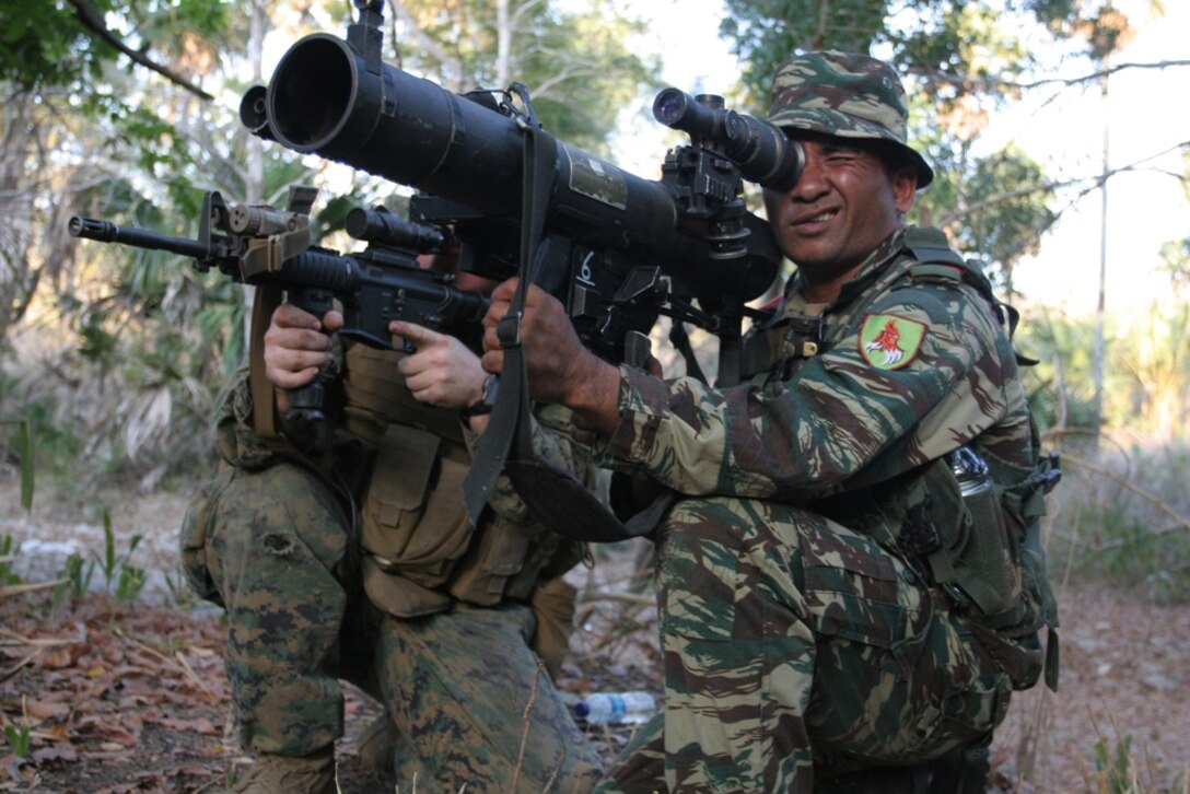 A Marine shows his Timor Leste counterpart how to operate a shoulder-launched multipurpose assault weapon during a training exercise here Oct. 17. The Marine is from Company E, Battalion Landing Team 2/4, the ground combat element of the 11th Marine Expeditionary Unit.