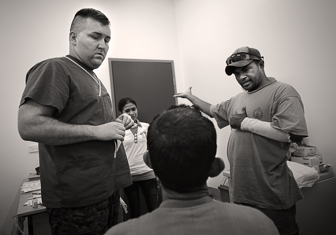 Navy Lt. Billy Turley and a local translator explain to the father of an ill child the severity of his son’s tooth infection, which had spread down the jaw and neck and formed an abscess that threatened to cut off the boy’s breathing. Turley removed seven decayed teeth and surgically drained the infection at the Santa Rosa Hospital in Oecussi, Timor Leste, Oct. 17.