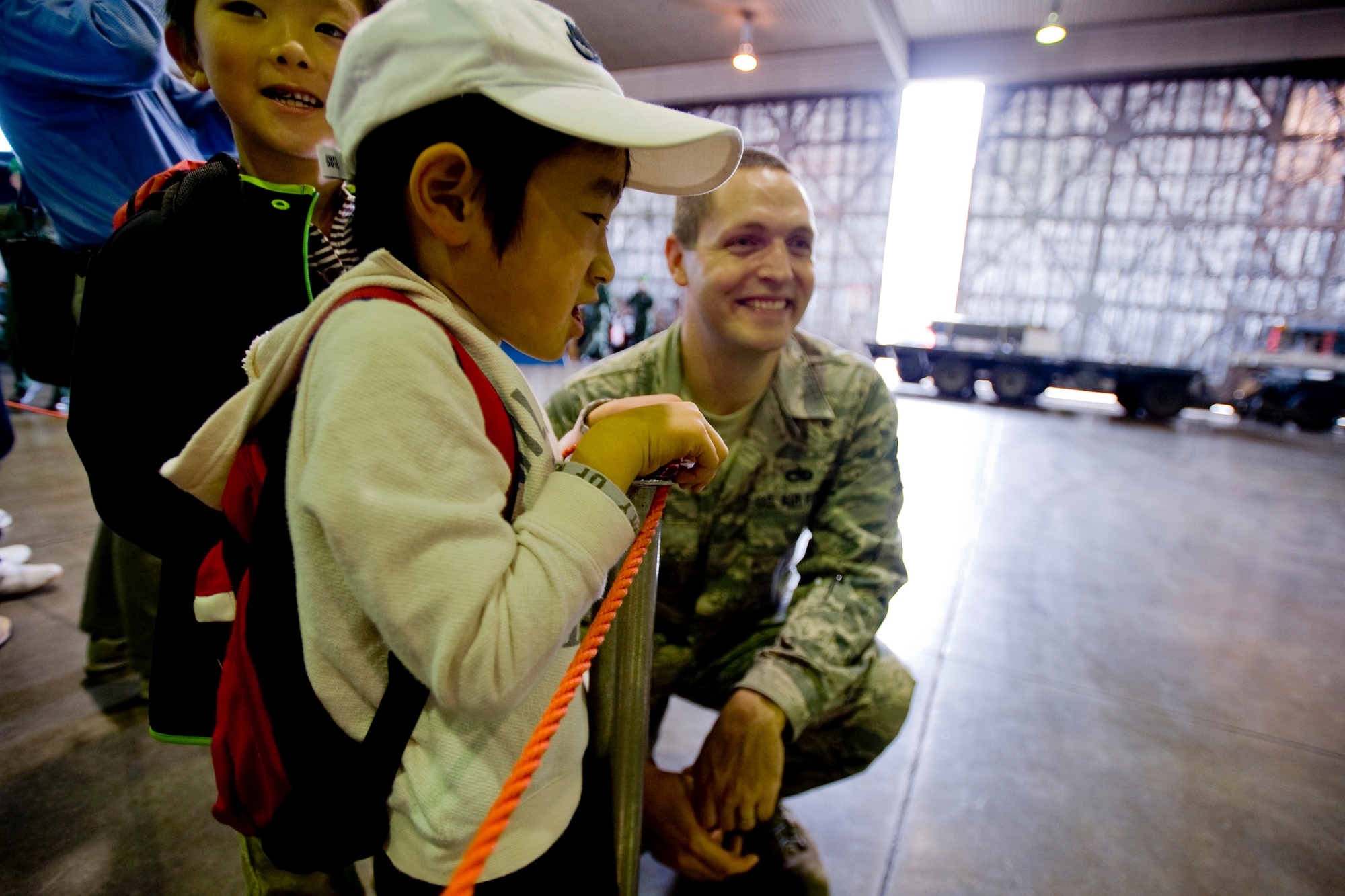 MISAWA AIR BASE, Japan -- Two Japanese children talk to Staff Sgt. Jason Bouse, 35th Maintenance Operation Squadron weapon-loads crewman, while waiting in line for pictures with an F-16 Fighting Falcon during the Misawa Air Fest 2009 Oct. 18. Sergeant Bouse took the opportunity to practice his Japanese. (U.S. Air Force photo/Senior Airman Jamal D. Sutter)