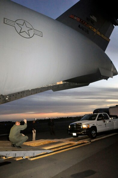 Help for American Somoa: Aircrew and FEMA members off-load supplies and equipment from the back of a 729th Airlift Squadron C-17 at Hickam AFB in Hawaii. The C-17 flew from March ARB to Dobbins ARB, Ga., Oct. 2, where 16 members of FEMA and a FEMA truck and communications trailer were boarded and flown to Hickam AFB as part of the humanitarian support mission after an earthquake and tsunami devastated the region. After Hickam, the C-17 flew three FEMA passengers and five generators to Pago Pago. On the return flight, the March aircraft carried Army National Guard Soldiers, first responders and Anthony M. Babauta, U.S. Assistant Secretary of the Interior for Insular Areas. March remained on alert for further tsunami relief missions from Oct. 1-6. (U.S. Air Force Photo/ Master Sgt. Daniel Nathaniel III)