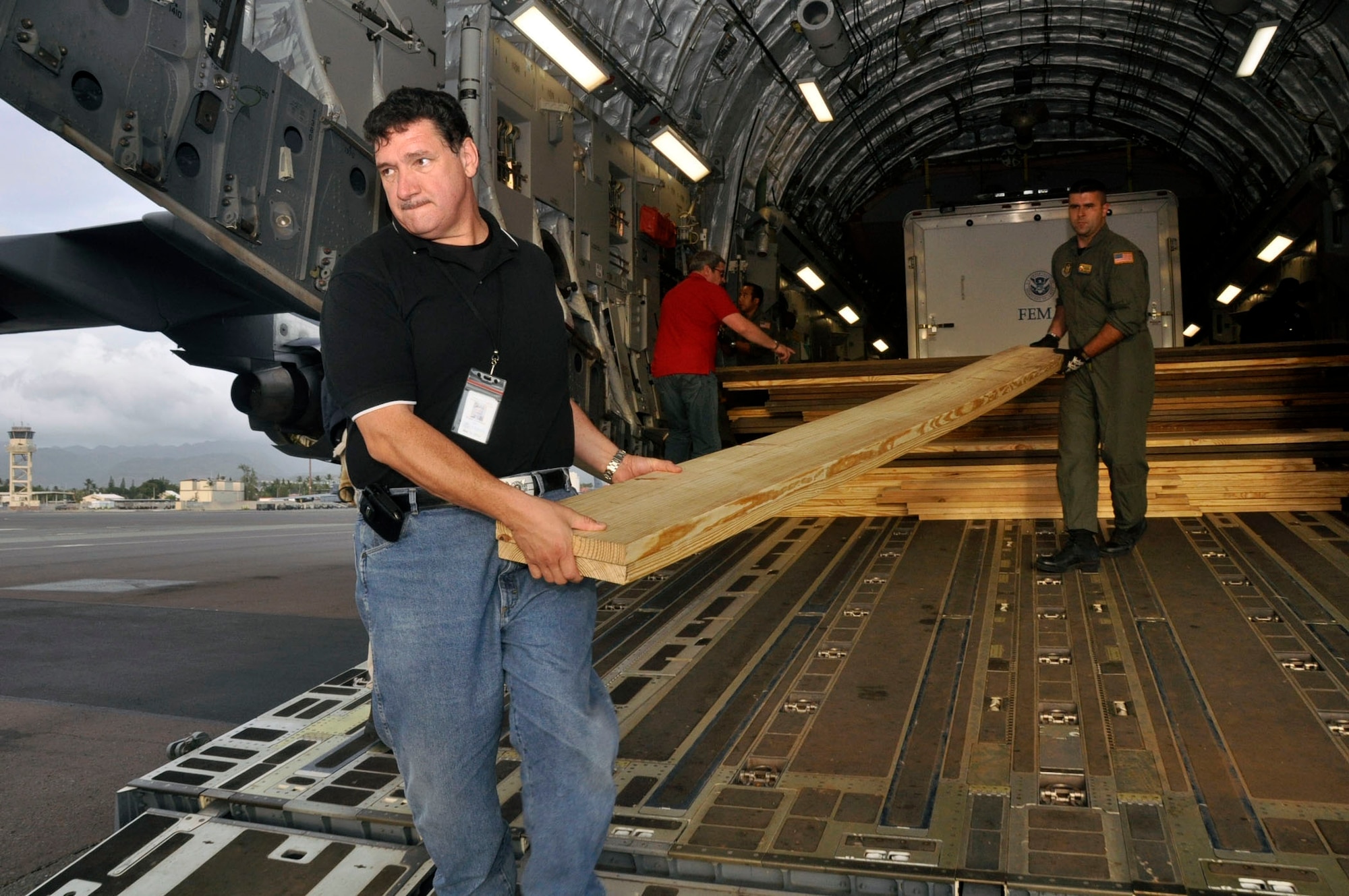 Help for American Somoa: Aircrew and FEMA members off-load supplies and equipment from the back of a 729th Airlift Squadron C-17 at Hickam AFB in Hawaii. The C-17 flew from March ARB to Dobbins ARB, Ga., Oct. 2, where 16 members of FEMA and a FEMA truck and communications trailer were boarded and flown to Hickam AFB as part of the humanitarian support mission after an earthquake and tsunami devastated the region. After Hickam, the C-17 flew three FEMA passengers and five generators to Pago Pago. On the return flight, the March aircraft carried Army National Guard Soldiers, first responders and Anthony M. Babauta, U.S. Assistant Secretary of the Interior for Insular Areas. March remained on alert for further tsunami relief missions from Oct. 1-6. (U.S. Air Force Photo/ Master Sgt. Daniel Nathaniel III)