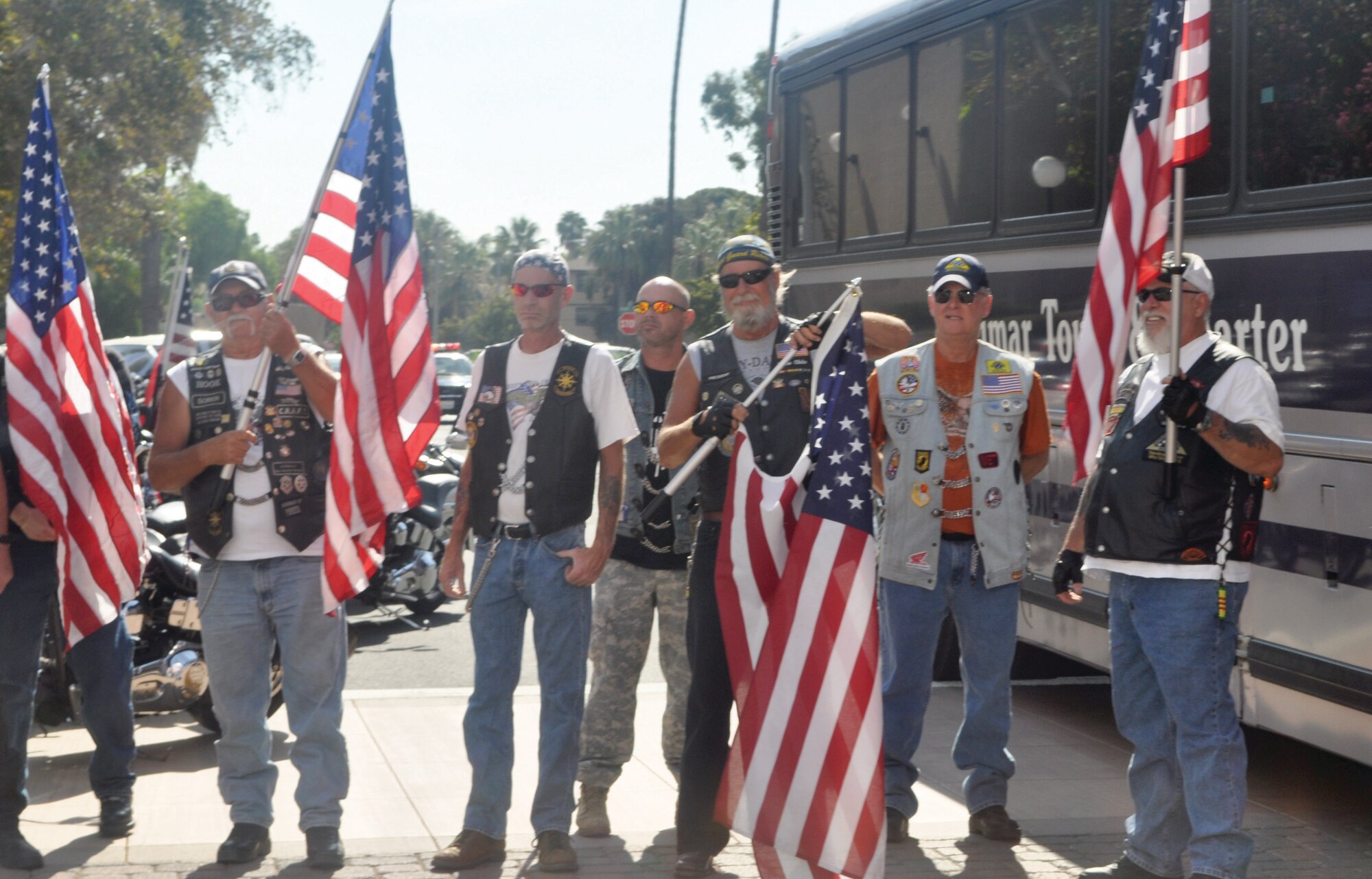 Members of the Patriot Guard Riders, who provided a motorcycle escort for the buses carrying the Soldiers, wave flags in support of the Soldiers. (U.S. Army photo by Sgt. Tracy Ellingsen)