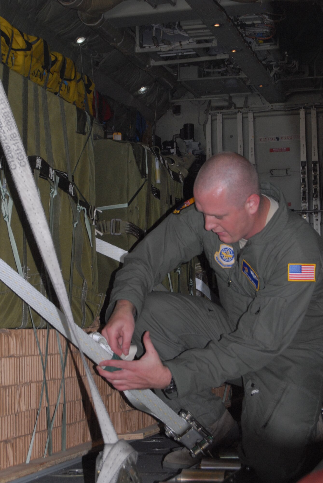 Staff Sgt. Richard Mumma, 2nd Airlift Squadron, secures a Container Delivery System bundle in preparation for a training mission Oct. 9. (Air Force photo by Rhonda Griffin)
