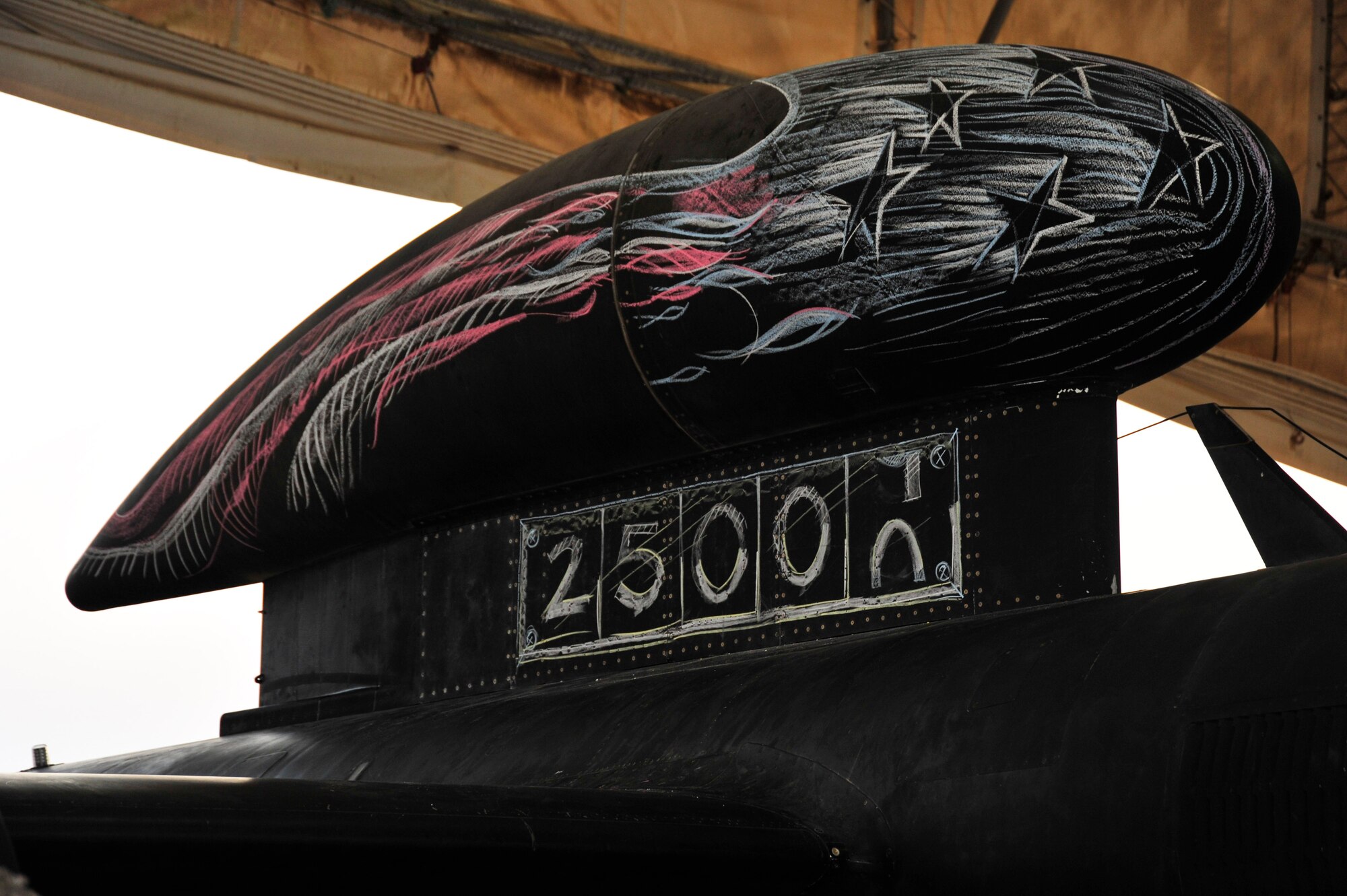SOUTHWEST ASIA—The U-2 Dragon Lady Aircraft No. 068-0337 exceeded its 25,000th hour of flight Oct. 18, 2009, in a mission out of the 380th Air Expeditionary Wing. Staff Sgt.’s Jason A. Ortiz and Michael L. McVey, 380th Expeditionary Aircraft Maintenance Squadron, sketched with chalk symbolic designs on the airframe, prior to the flight. (U.S. Air Force Photo by 2nd Lt. Kidron B. Vestal)   