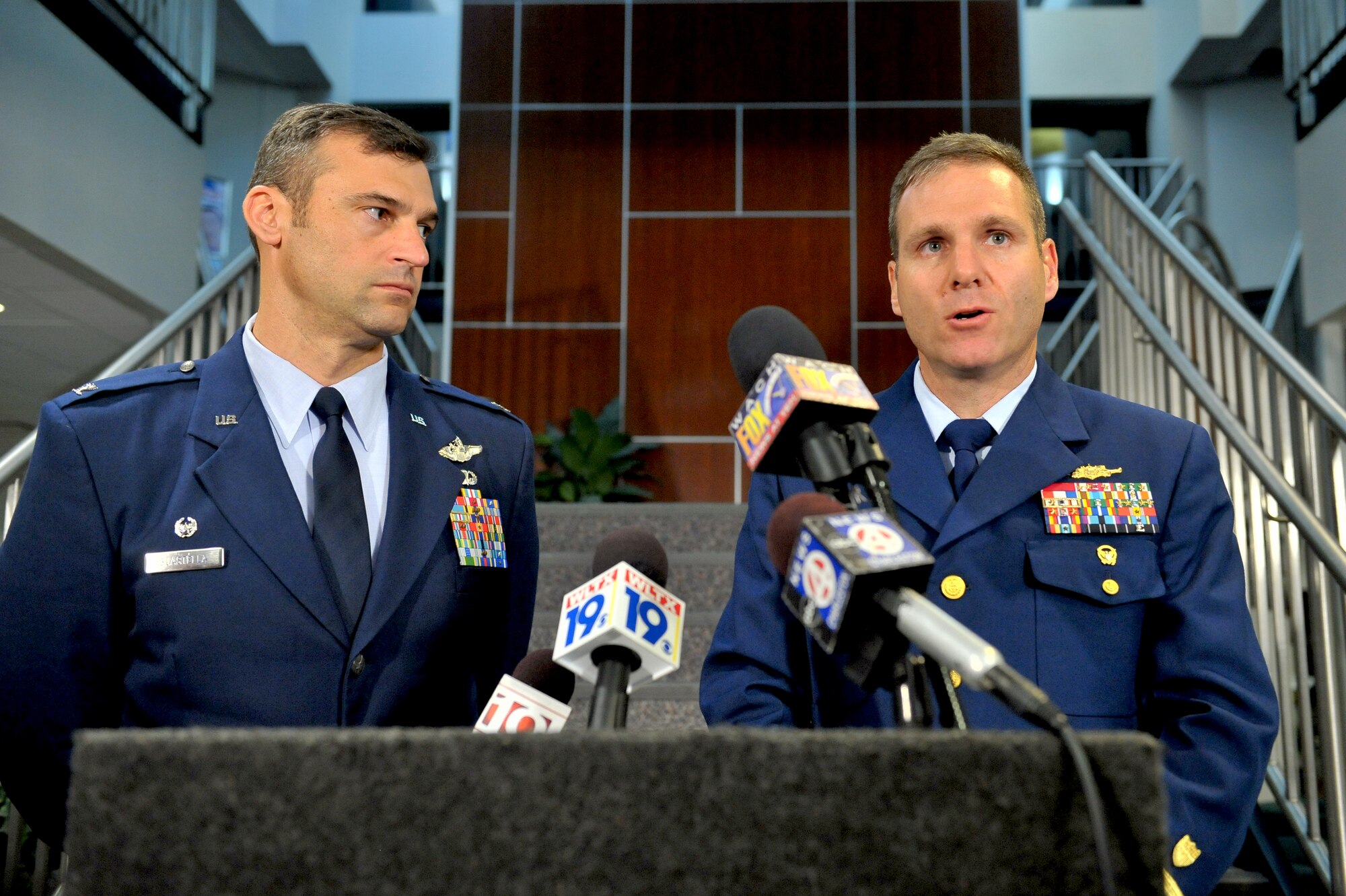 Captain Michael McAllister, U.S. Coast Guard Sector Charleston commander, right, addresses the media with Col. Joseph Guastella, 20th Fighter Wing commander, Oct. 17. The joint service press conference announced that the search for a missing Air Force pilot involved in a mid-air collision Oct. 15, Capt. Nicholas Giglio, has been suspended and has turned into a recovery operation. The investigation of the mid-air collision revealed the impact breached Captain Giglio's canopy, causing fatal injuries. (U.S. Air Force photo/Senior Airman Kathrine McDowell)
