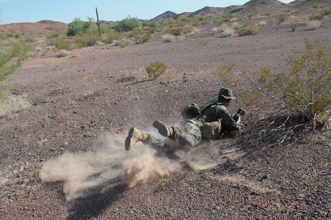 Lance Cpl. Ben Norville, an armory custodian with Headquarters and Service Company, 1st Battalion, 2nd Marine Regiment, slides into position during infantry tactics training at Graze Range at the U.S. Army Yuma Proving Ground in Arizona, Oct. 18, 2009. Comprised of Marines with noninfantry specialties, the Camp Lejeune, N.C.-based company is preparing to operate as an infantry company during their upcoming deployment to Afghanistan in the spring of 2010.