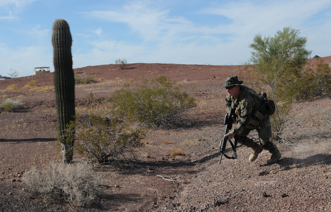 Lance Cpl. Ben Norville, an armory custodian with Headquarters and Service Company, 1st Battalion, 2nd Marine Regiment, rushes forward during infantry tactics training at Graze Range at the U.S. Army Yuma Proving Ground in Arizona, Oct. 18, 2009. Comprised of Marines with noninfantry specialties, the Camp Lejeune, N.C.-based company is preparing to operate as an infantry company during their upcoming deployment to Afghanistan in the spring of 2010.