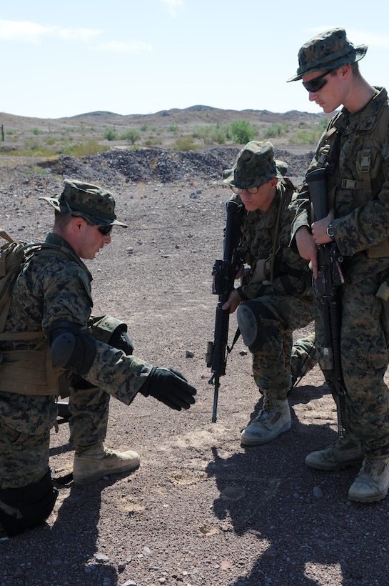 Lance Cpl. Edward Joltnston, left, an infantryman from 1st Battalion, 2nd Marine Regiment, shows Lance Cpl. Shane Palmer and Lance Cpl. Christopher Huenneke of Headquarters and Service Company, the proper layout of a wedge formation during infantry tactics training at Graze Range at the U.S. Army Yuma Proving Ground in Arizona, Oct. 18, 2009. Comprised of Marines with noninfantry specialties, the Camp Lejeune, N.C.-based company is preparing to operate as an infantry company during their upcoming deployment to Afghanistan in the spring of 2010.
