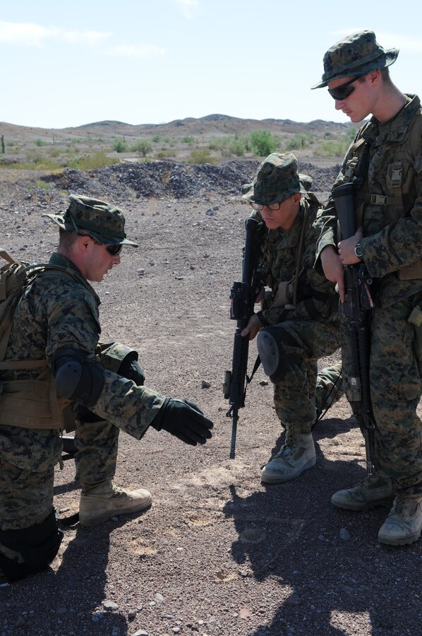 Lance Cpl. Edward Joltnston, left, an infantryman from 1st Battalion, 2nd Marine Regiment, shows Lance Cpl. Shane Palmer and Lance Cpl. Christopher Huenneke of Headquarters and Service Company, the proper layout of a wedge formation during infantry tactics training at Graze Range at the U.S. Army Yuma Proving Ground in Arizona, Oct. 18, 2009. Comprised of Marines with noninfantry specialties, the Camp Lejeune, N.C.-based company is preparing to operate as an infantry company during their upcoming deployment to Afghanistan in the spring of 2010.