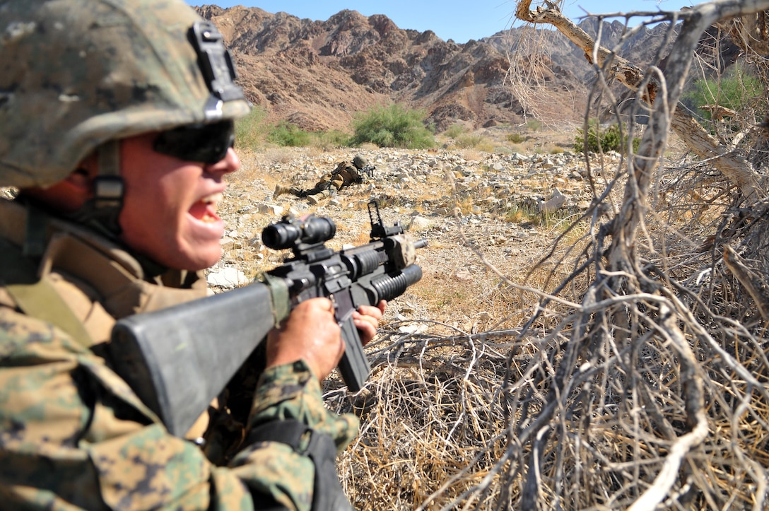 A Marine from Company A, 1st Battalion, 2nd Marine Regiment, lays down suppressive fire as fire team leader Lance Cpl. Jacob Carter shouts commands to his Marines as they advance on targets during a live-fire ambush and reaction drill at the Camp Billy Machen desert warfare training facility in the Chocolate Mountain Aerial Gunnery Range in California Oct. 18, 2009. The Camp Lejeune, N.C.-based company spent three days at the camp, making use of its rocky, mountainous terrain to prepare for an upcoming deployment to Afghanistan early next year, holding classes and executing live-fire immediate action drills and combat patrols. The live-fire drills were all carried out without dry runs, creating an environment of uncertainty for the Marines to train in. “When you do a dry run, you can better scheme your maneuvers,” said Carter, 22, of Lakeland, Fla. “But this gets team leaders to think on the fly and prepares us for combat. The harder we train here, the easier things will be in country.”