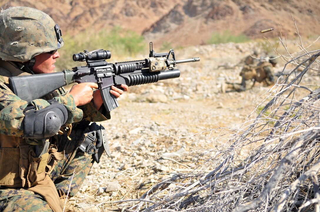 Lance Cpl. Jacob Carter, a fire team leader with Company A, 1st Battalion, 2nd Marine Regiment, squeezes off a round as his Marines advance on targets during a live-fire ambush and reaction drill at the Camp Billy Machen desert warfare training facility in the Chocolate Mountain Aerial Gunnery Range in California Oct. 18, 2009. The Camp Lejeune, N.C.-based company spent three days at the camp, making use of its rocky, mountainous terrain to prepare for an upcoming deployment to Afghanistan early next year, holding classes and executing live-fire immediate action drills and combat patrols. ::r::::n::The live-fire drills were all carried out without dry runs, creating an environment of uncertainty for the Marines to train in. “When you do a dry run, you can better scheme your maneuvers,” said Carter, 22, of Lakeland, Fla. “But this gets team leaders to think on the fly and prepares us for combat. The harder we train here, the easier things will be in country.”
