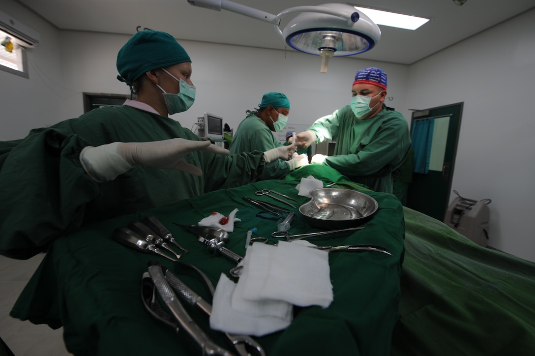 Petty Officer 2nd Class Rachel Arndt, from Wauwatosa, Wis., assists Navy Lt. Billy Turley, from Auburn, Ky., during surgery on an Oecussi man at the Santa Rosa Hospital here Oct. 18. Arndt and Turley are part of a medical team from the 11th Marine Expeditionary Unit that has been providing medical and dental care for Timor Leste citizens at numerous locations there.